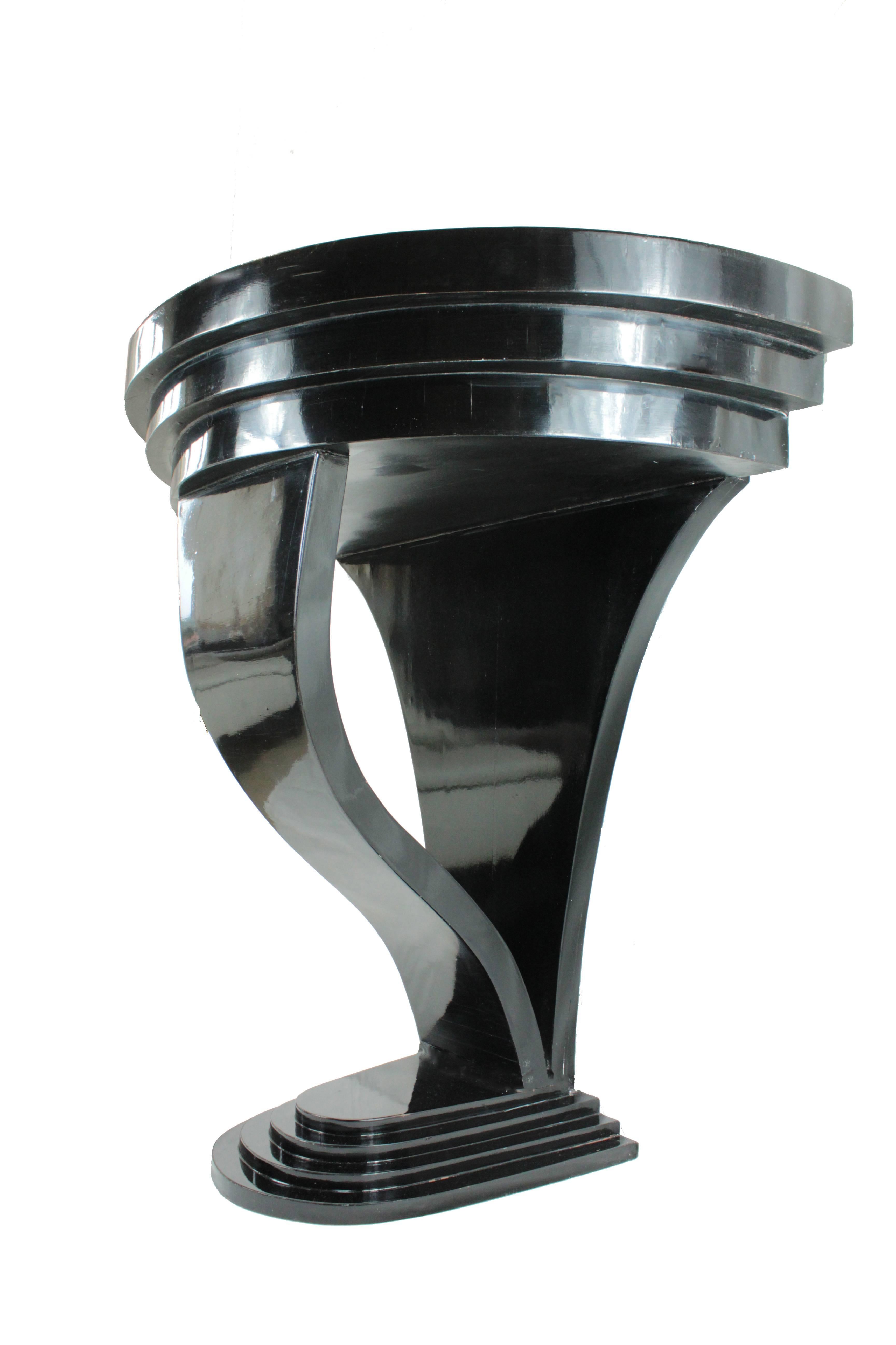 Italian Art Deco console made of black varnished olivewood made in the first half of the 20th century. The table form imitates a half-moon with a concave base. Excellent conditions.