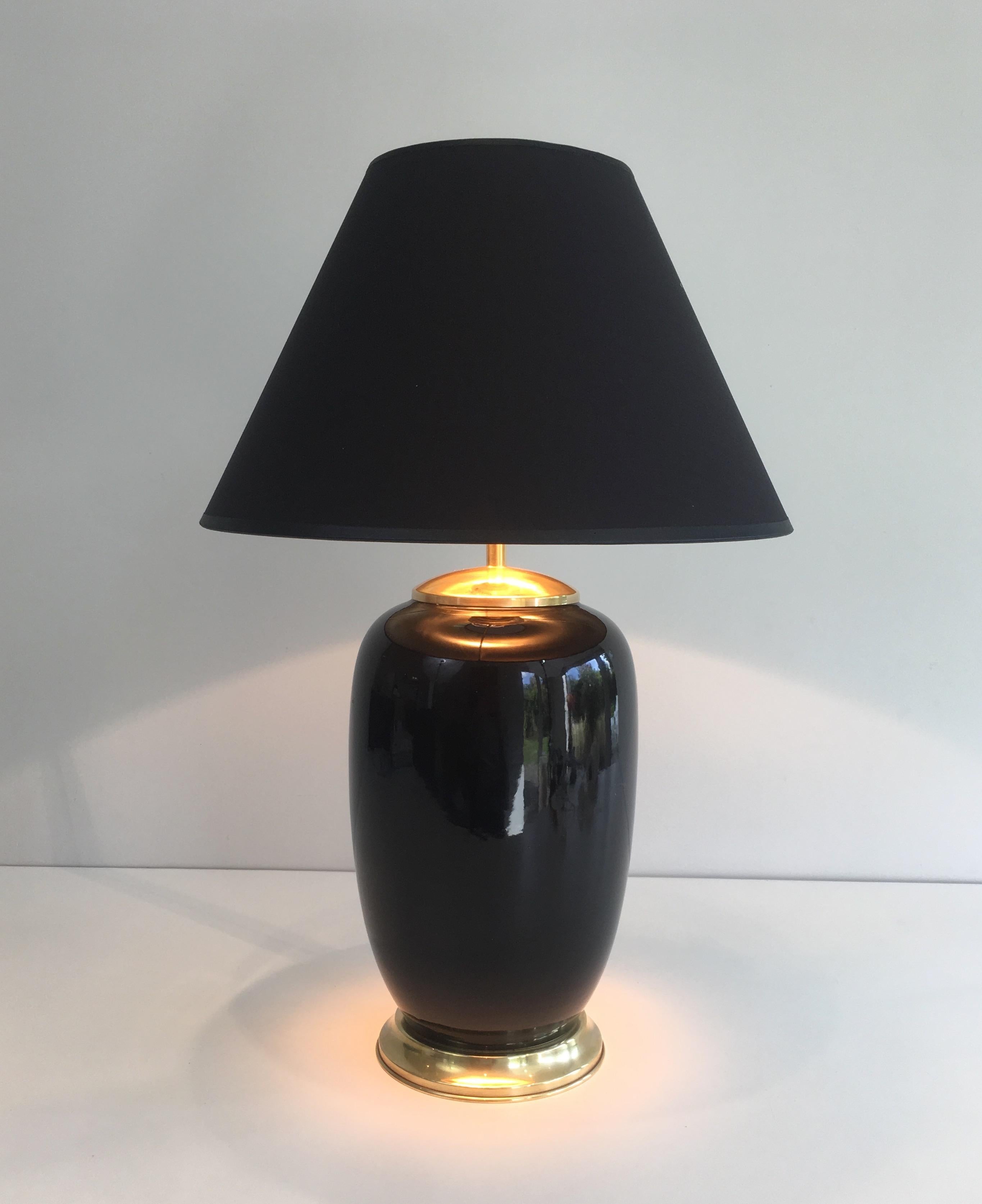 This decorative table lamp is made of black porcelain and brass. This is a French work, circa 1970.