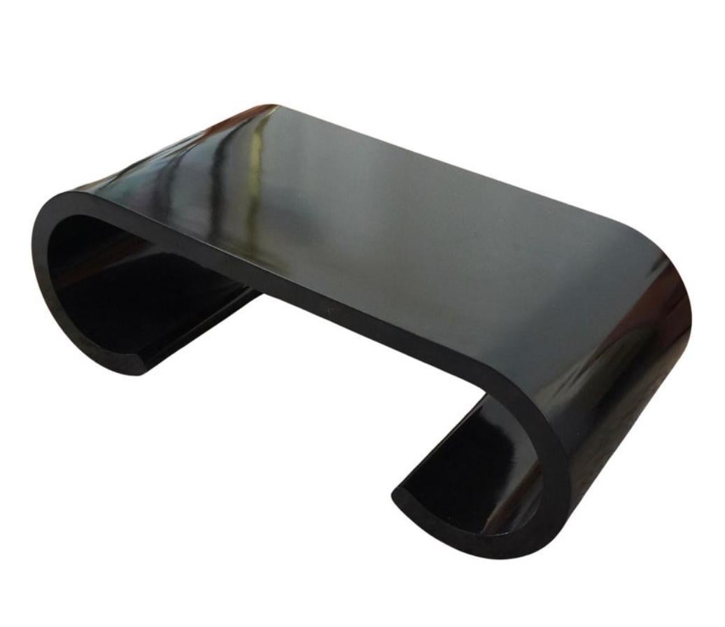 Stunning lacquered black scroll coffee table. It was made in the 1970s in the style of Karl Springer.The scroll design remains timeless both in its quality and its structure. This coffee table will look stunning in any home and complement both