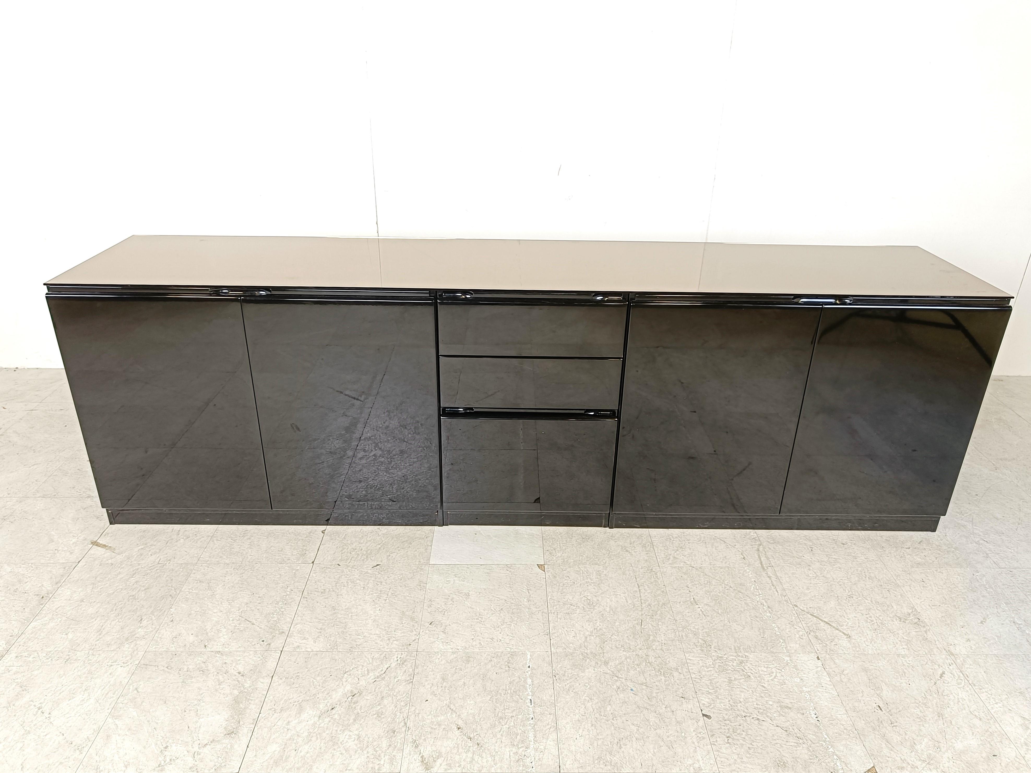 High gloss black lacquer credenza with 4 doors and 3 drawers.

High quality seventies sideboard with a timeless and minimalist design

The sideboad has a mirrored glass top

Good condition

1970s - Italy

Dimensions:
Lenght: 235cm/92.51
