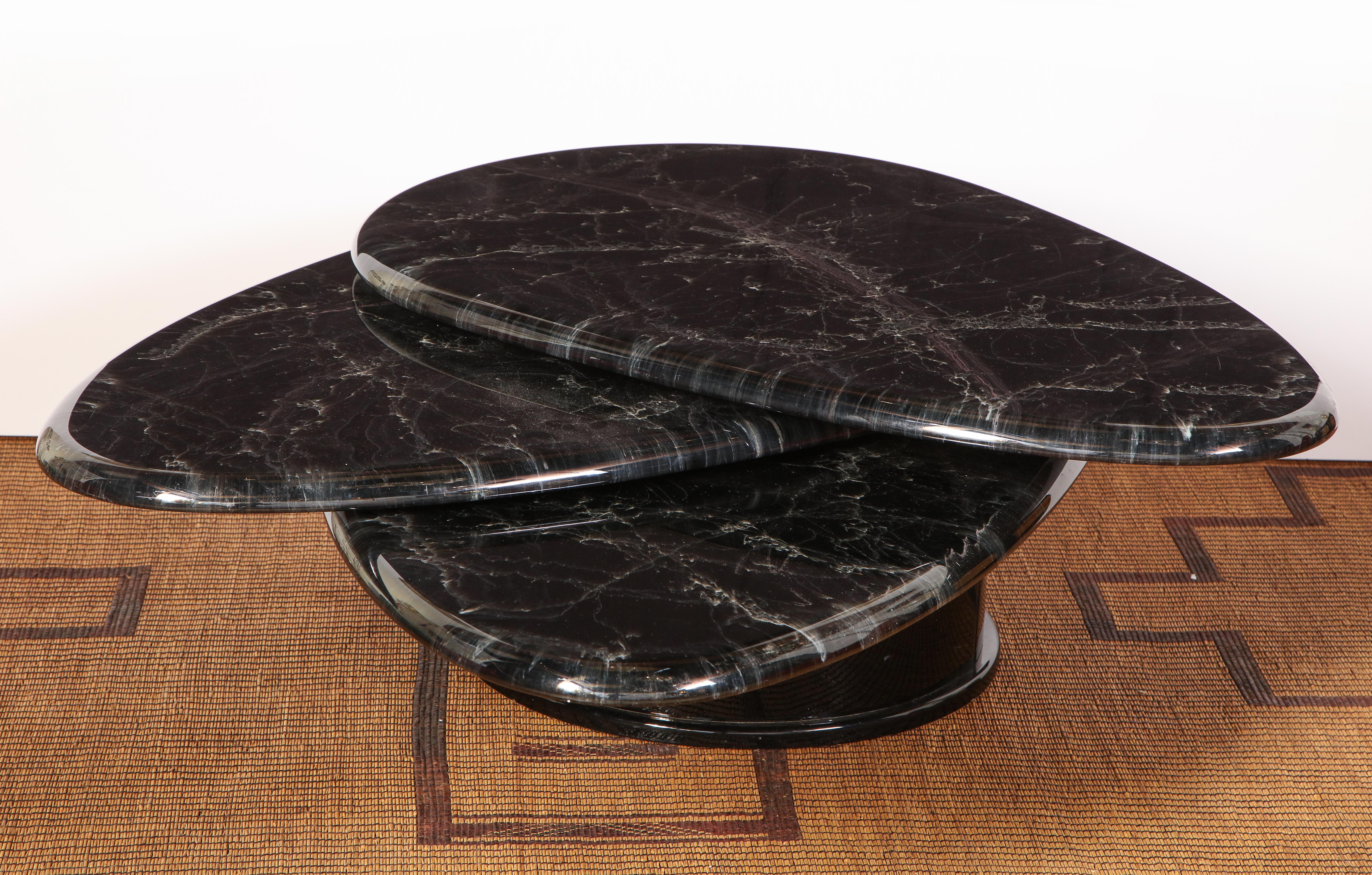 Black lacquered teardrop swivel coffee table attributed to Roger Rougier, circa 1980s. What makes this table unique and rare is the marbled top which is actually hand painted and lacquered and is virtually indistinguishable from real marble. The top