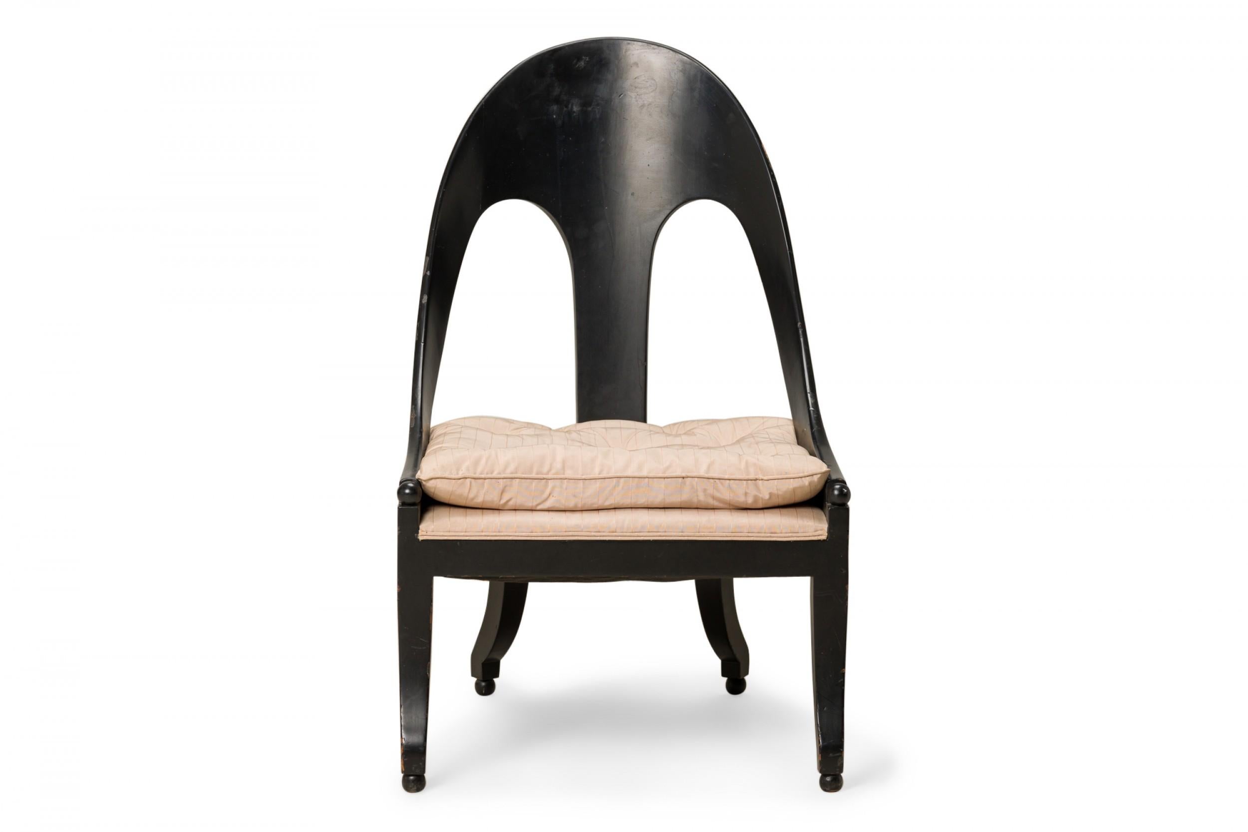 American mid-century spoon back side / pull up chair with a black lacquered wooden frame and a button-tufted rose fabric upholstered seat, resting on four square curved legs ending in ball feet.