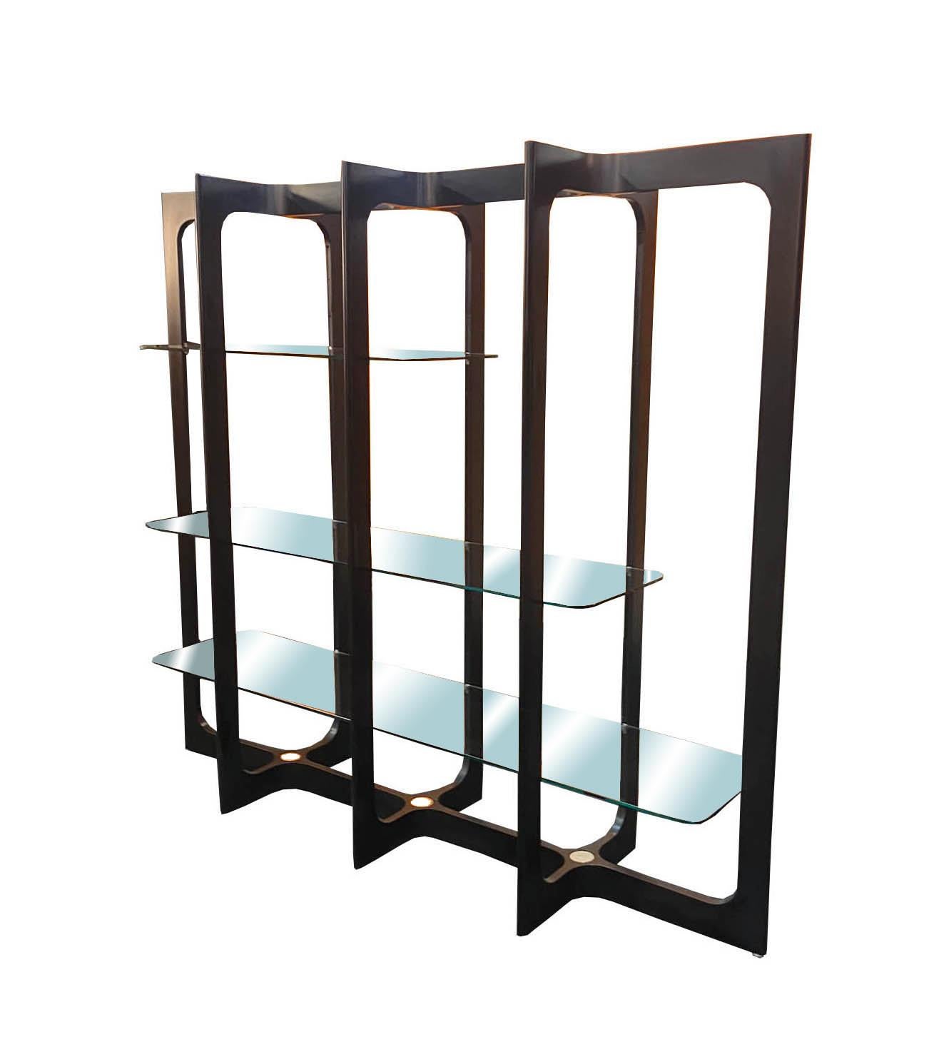 Etagere, bookcase or room divider from the 1970s made of black curved solid wood, 3 glass shelves and round chrome-plated steel supports. Its lines create a rhythm and a geometric design. Production Bernini, Italy 1970.