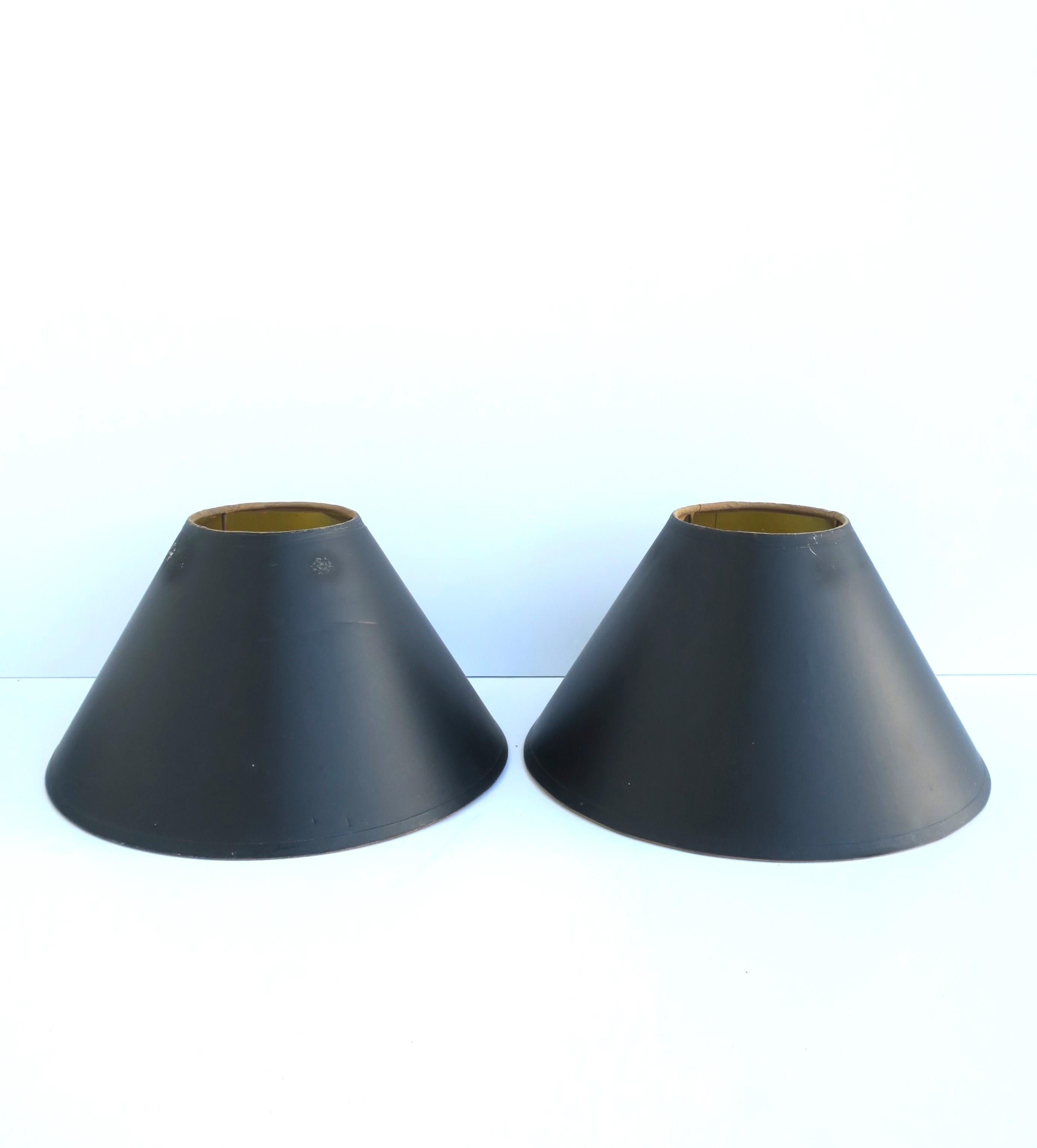 A pair of relatively small black paper lampshades [lamp shades] with gold interior and brass hardware. Dimensions: 11.25