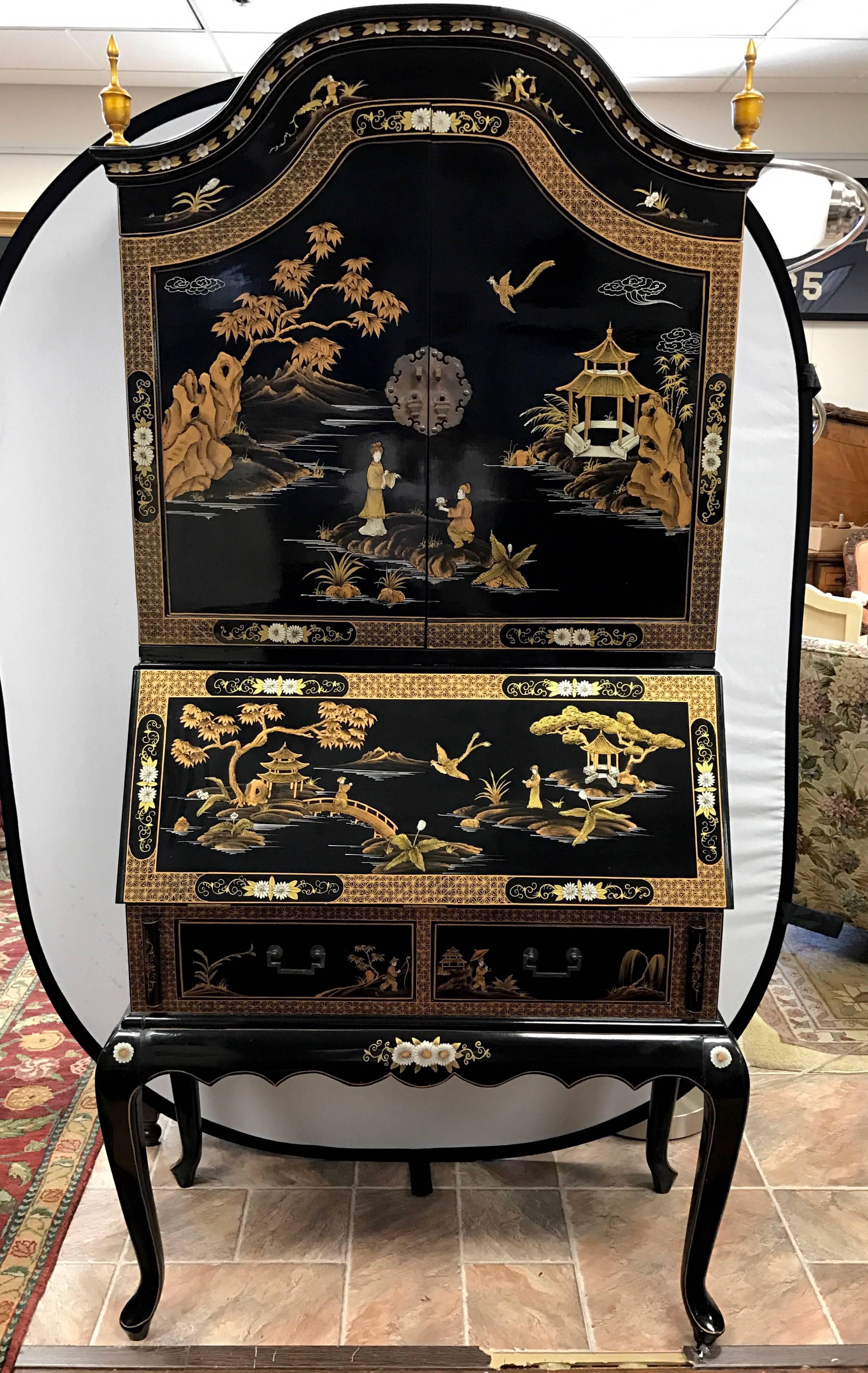Black and gold chinoiserie vintage Asian secretary desk that comes with matching chair. Spectacular painted scenery of Chinese landscape including birds and flowers. Comes with separate top and bottom. Top doors open to shelves. Bottom opens to drop