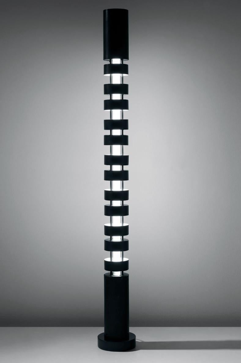 Dans sa période Post Black Shapes, Serge Mouille expérimente la couleur et les colonnes. Avec le Totem, il a empilé des abat-jour cylindriques autour d'un élément d'éclairage central. En alternant les stores vers le haut ou vers le bas, l'intensité
