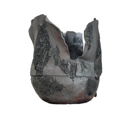 Skulpturales Gefäß aus schwarzer Lava, bei dem Bewegung und Form im Mittelpunkt stehen