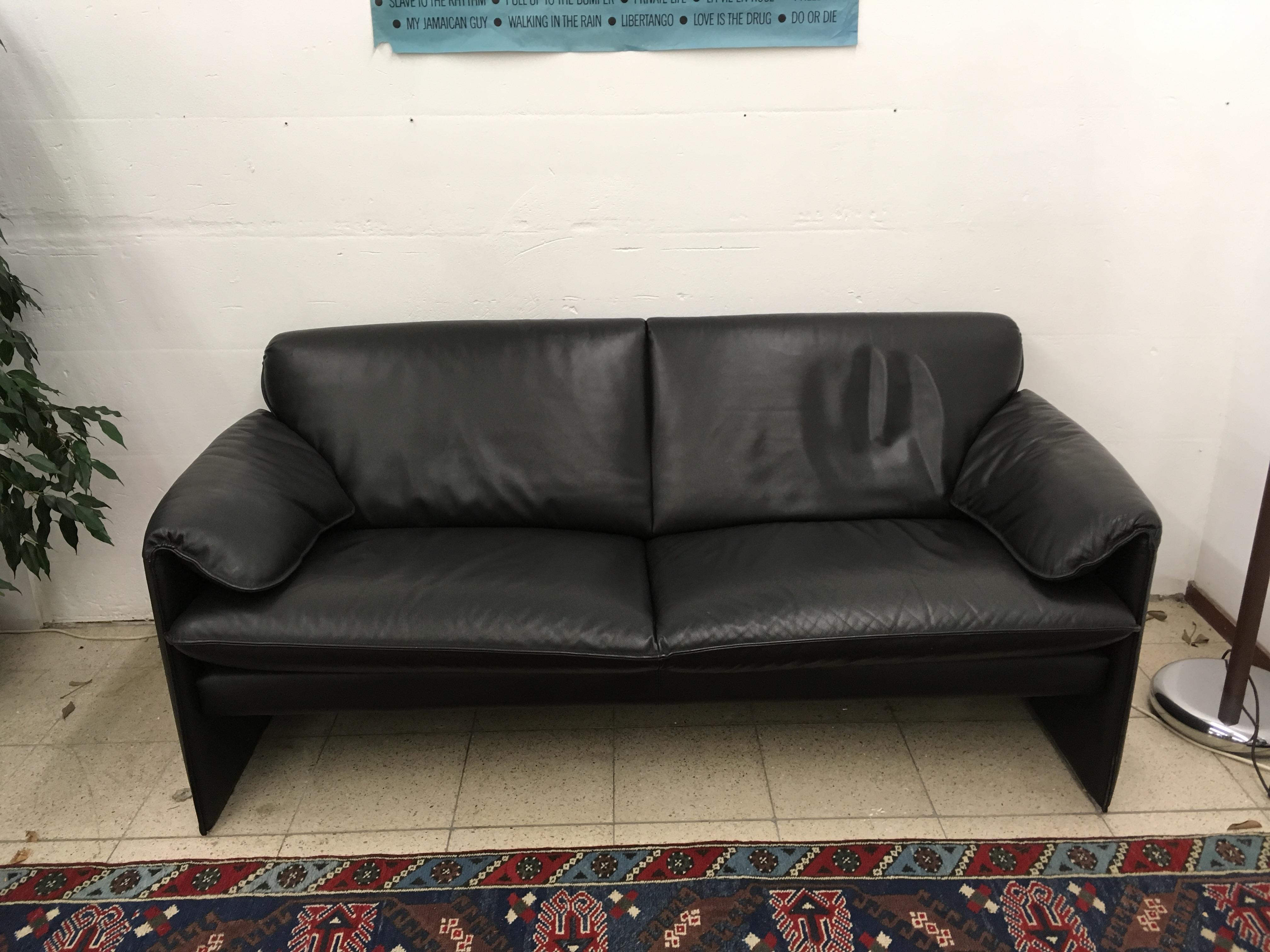 This 2.5-seat black leather sofa was designed by Axel Enthoven for Leolux in 1983. It has a comfortable seat and remains in good vintage condition with light traces of age and use. The piece wears the manufacturer's label. 