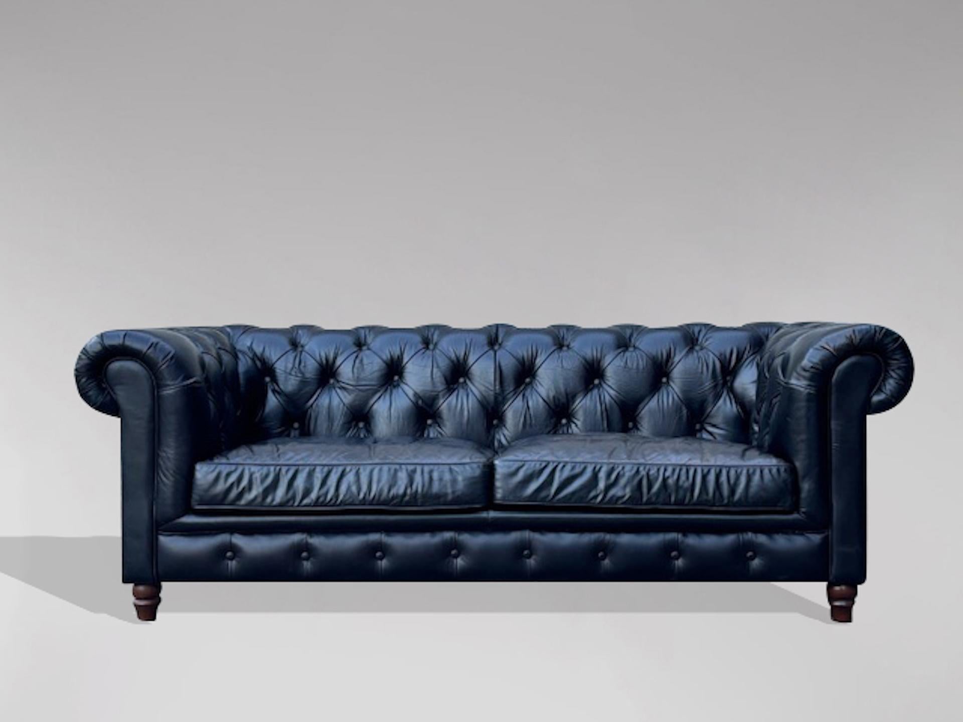 Chesterfield a tre posti in pelle nera di buona qualità della metà del XX secolo, con due grandi cuscini sciolti e gambe tornite. Con finiture in borchie d'ottone fissate a mano individualmente. Un bell'esempio di chesterfield di buona qualità con