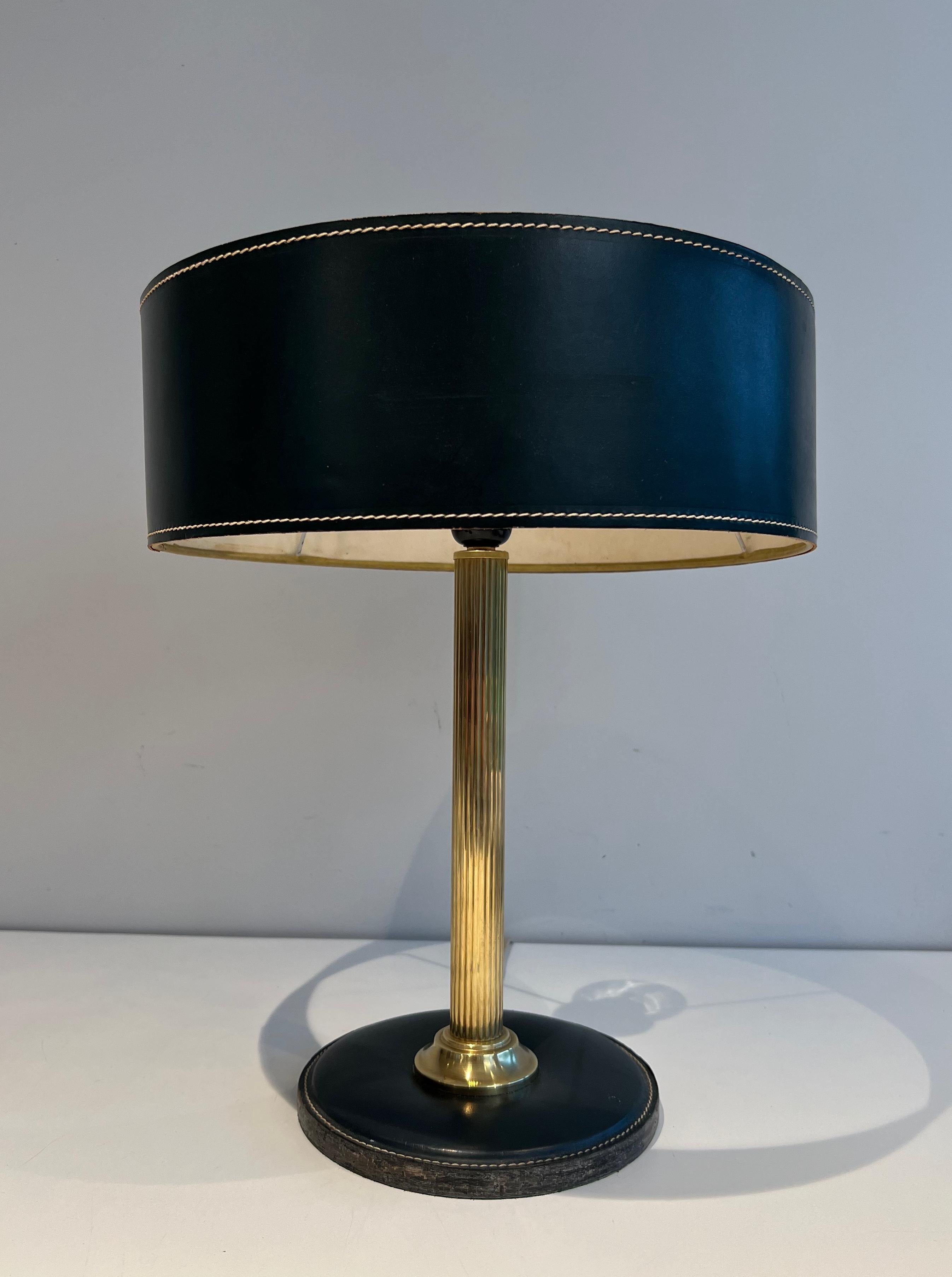 Cette très belle et élégante lampe de table est composée d'un cuir noir et de laiton. Il s'agit d'une œuvre française dans le style de Jacques Adnet. Circa 1970