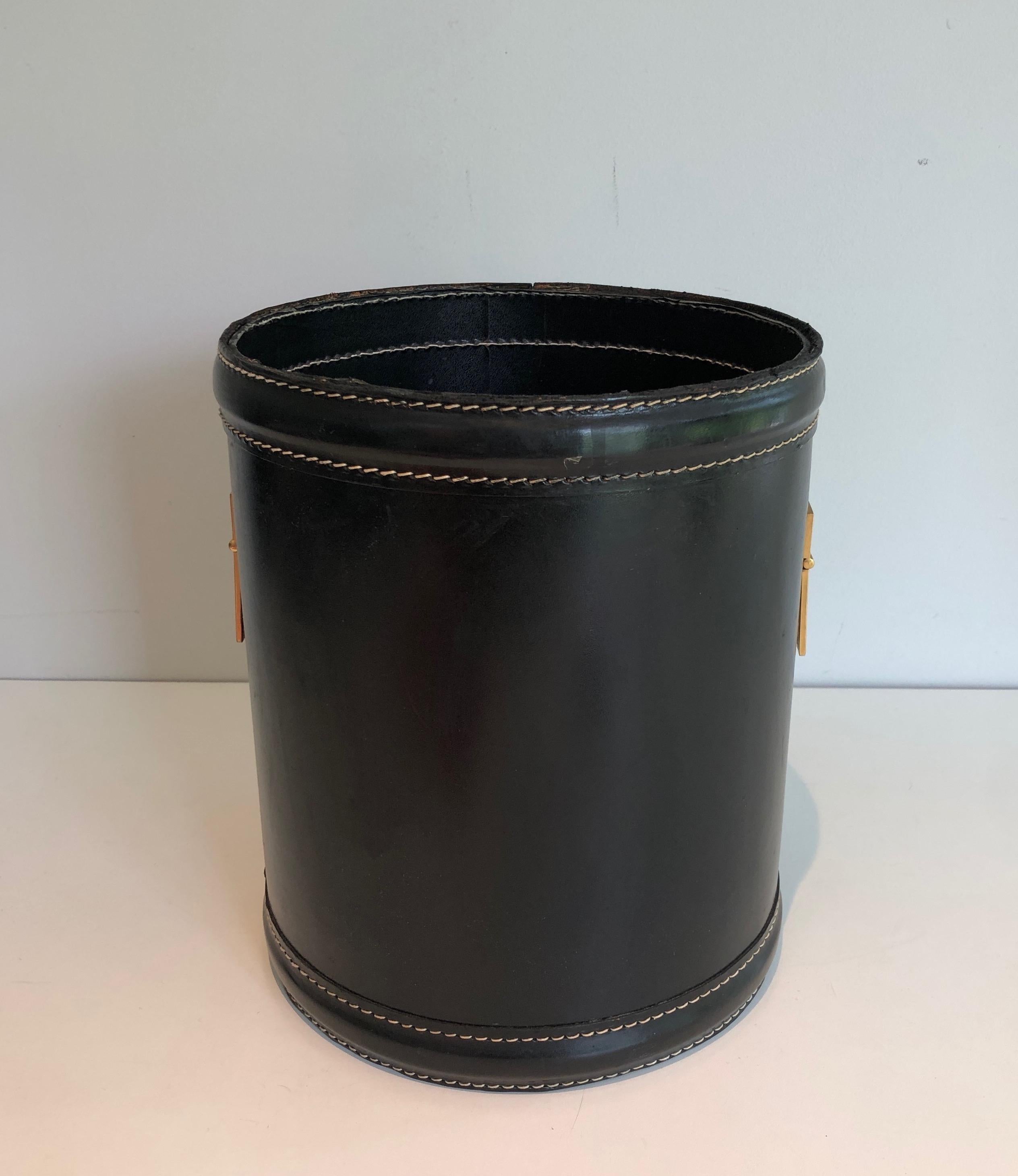 This very nice and chic waste paper basket is made of black leather and brass. This is a very elegant piecein the style of famous french designer Jacques Adnet. Circa 1970.