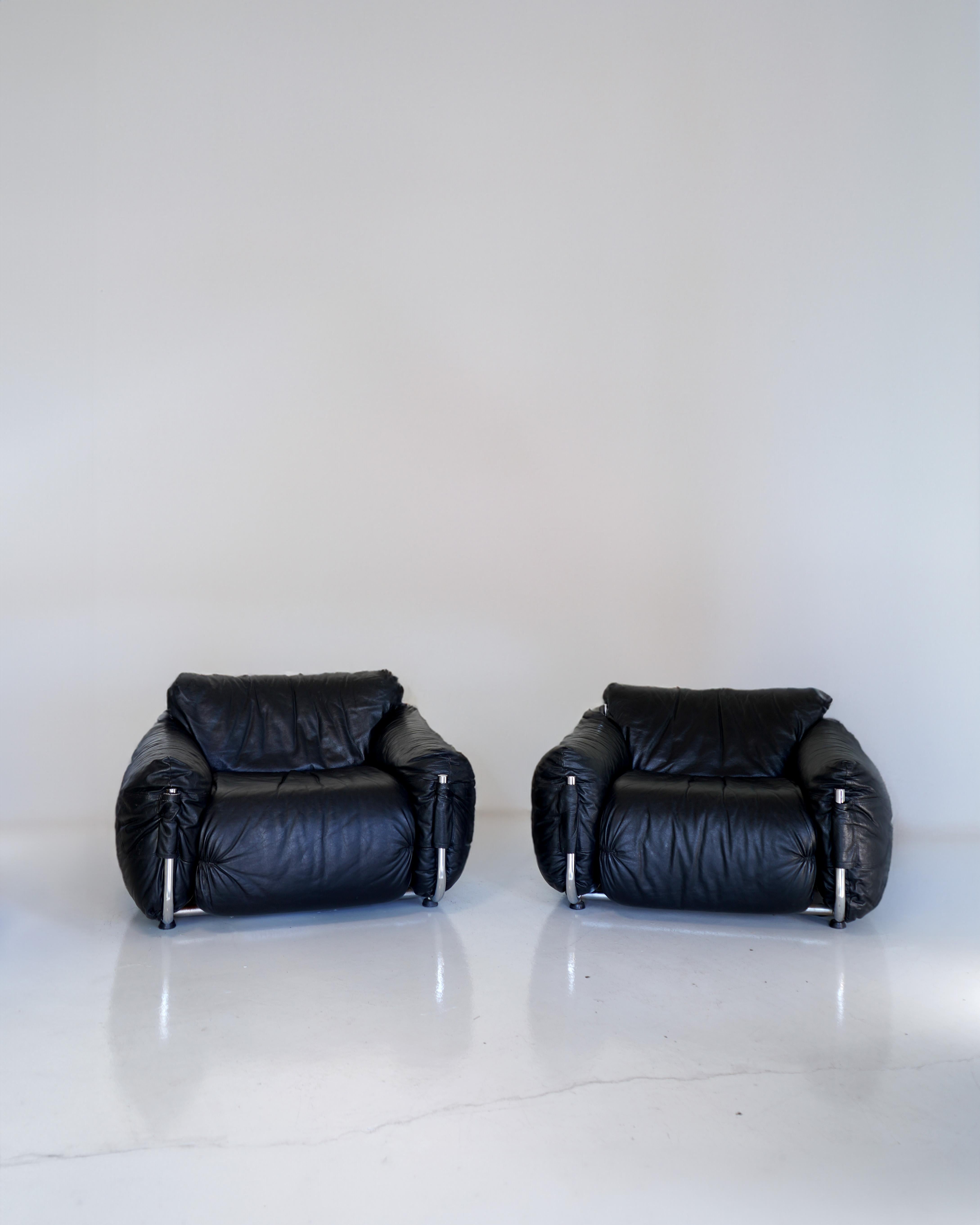 Striking Giuseppe Munari armchairs. Pillowy black leather cushions on a sleek frame of thick, tubular steel. A perfect blend of style and comfort, the sit is comfortable and supported without excessive sinking. Brilliant minimalist design, the