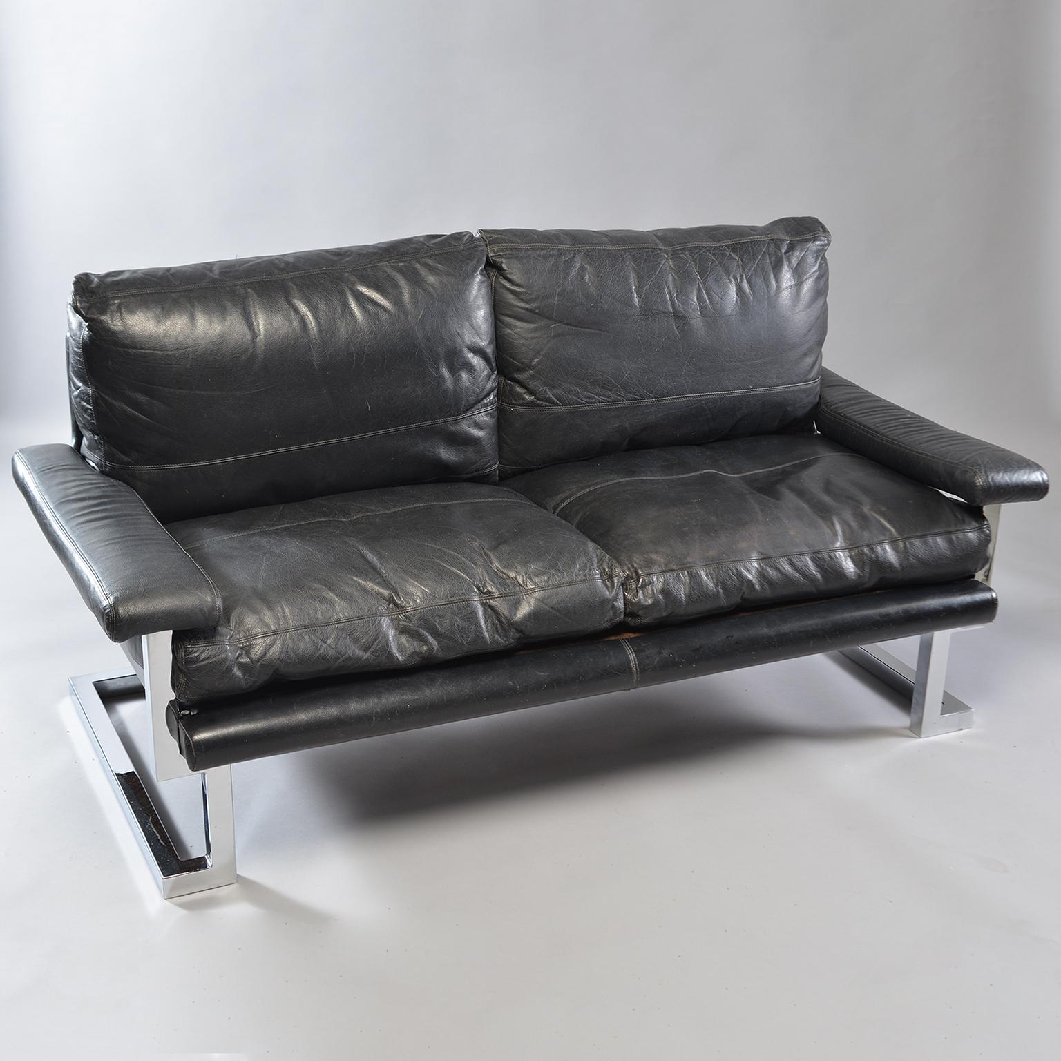 Black leather and chrome sofa designed by Tim Bates for the Mandarin Collection of UK furniture maker Pieff & Co, circa 1970s. Comfortable with classic midcentury lines and style. Padded arm rests, pebble finished leather and chromed steel frame.