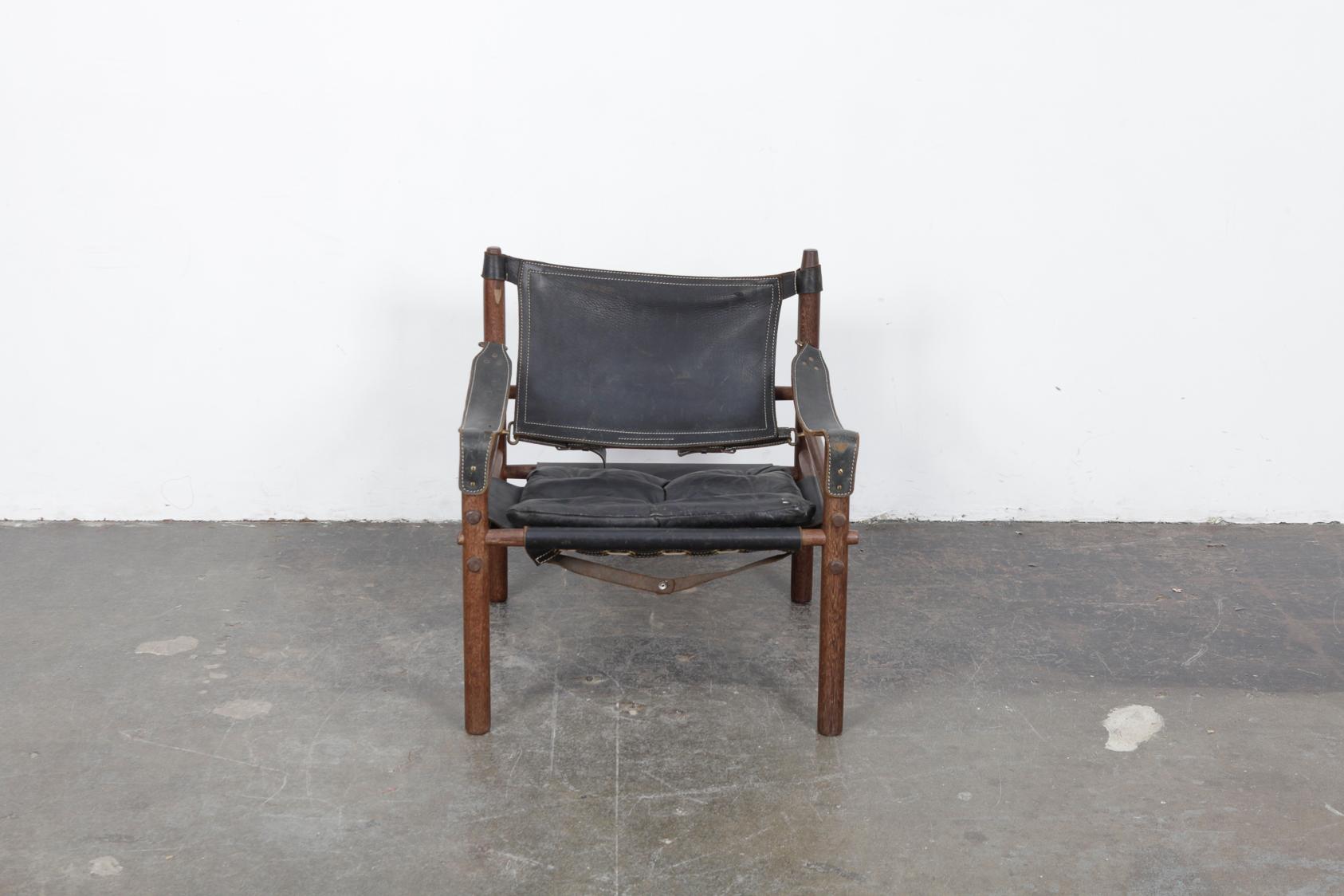 Safari chair by Swedish designer Arne Norell for Norell AB, in original black leather with oak frame. Nice patina to the leather, frame has been waxed and is clean. Leather strap that attaches to the wood support on the upper right top has been