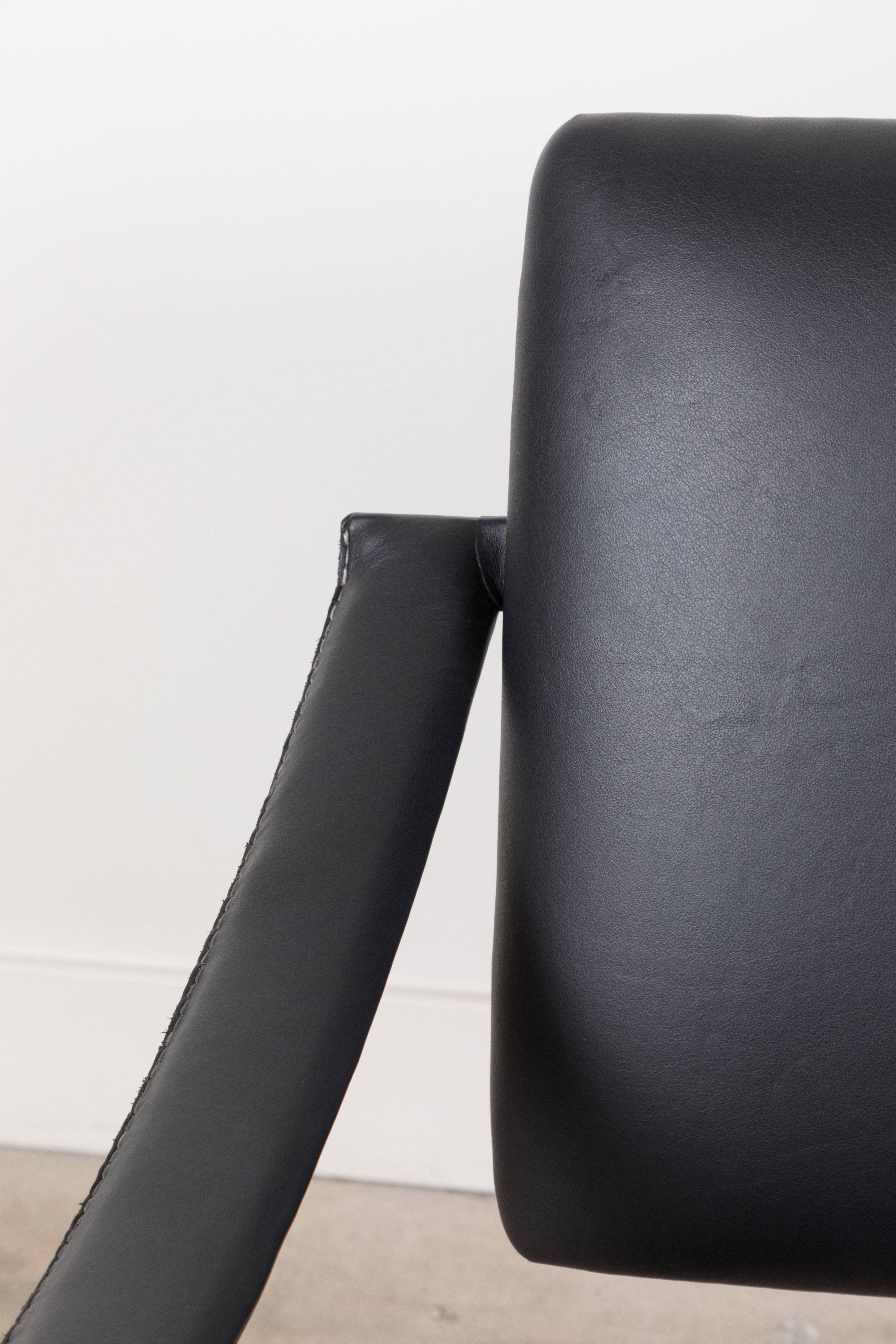 Black leather armchair by Jacques Adnet.