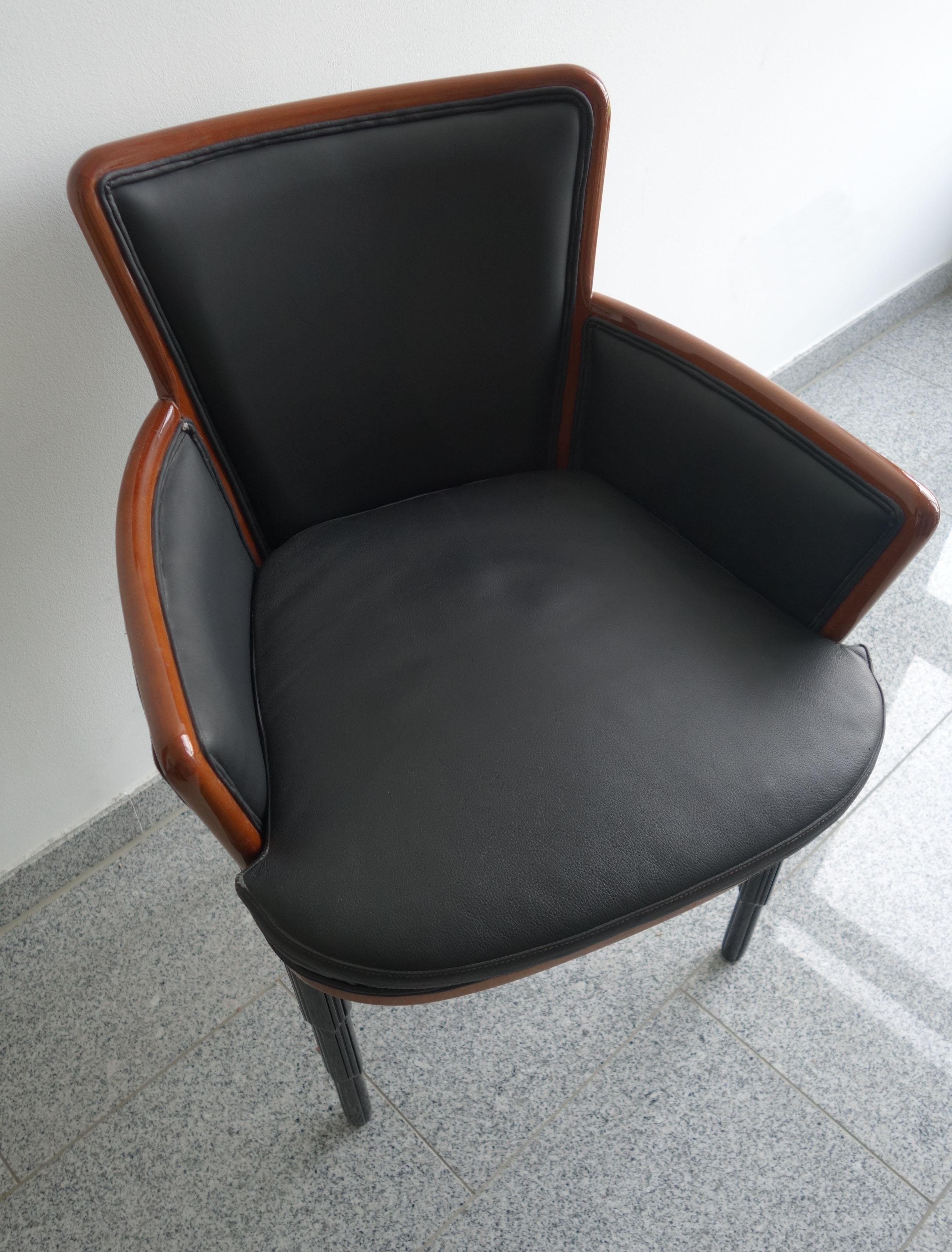 This beautiful armchair is made with a rounded wooden frame. The legs are in stepped black wood and the armchair is upholstered in high quality black leather. 
The chair was not used.
 