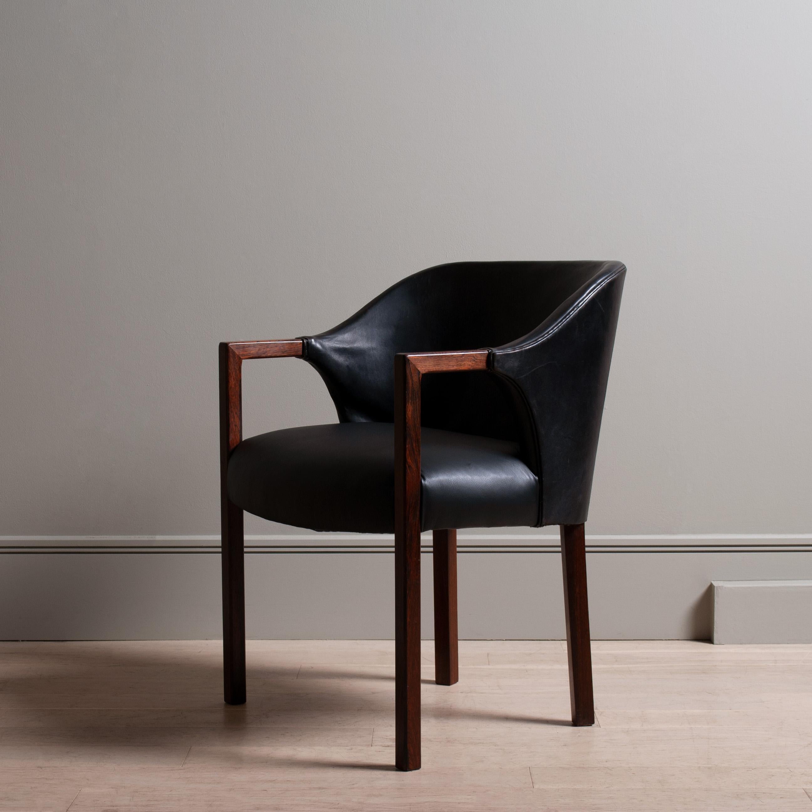 An incredibly unusual Danish design armchair of superb design, attributed to renowned furniture designer Jacob Kjaer. Perfectly angled mitre jointed arms leading to very unique sweeping original and patinated black leather upholstery. Created in the