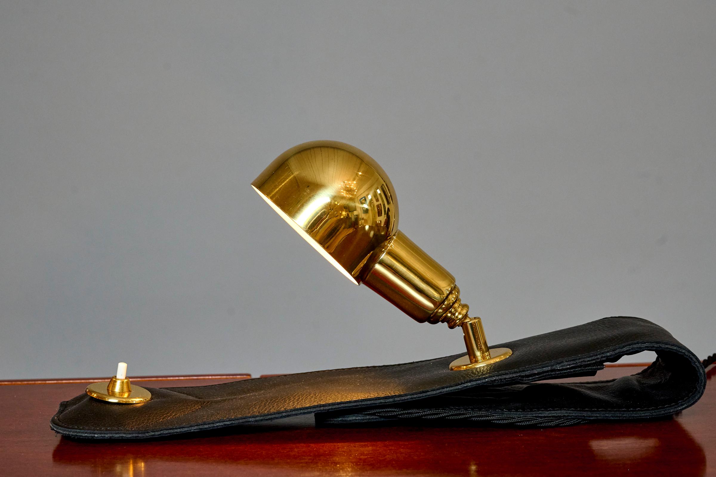 An armchair, headboard lamp by Dominioni in black leather with brass shade and switch. 

The light can be used on a table, shelf or over a chair, or bed headboard.

In excellent condition. Fully functional.