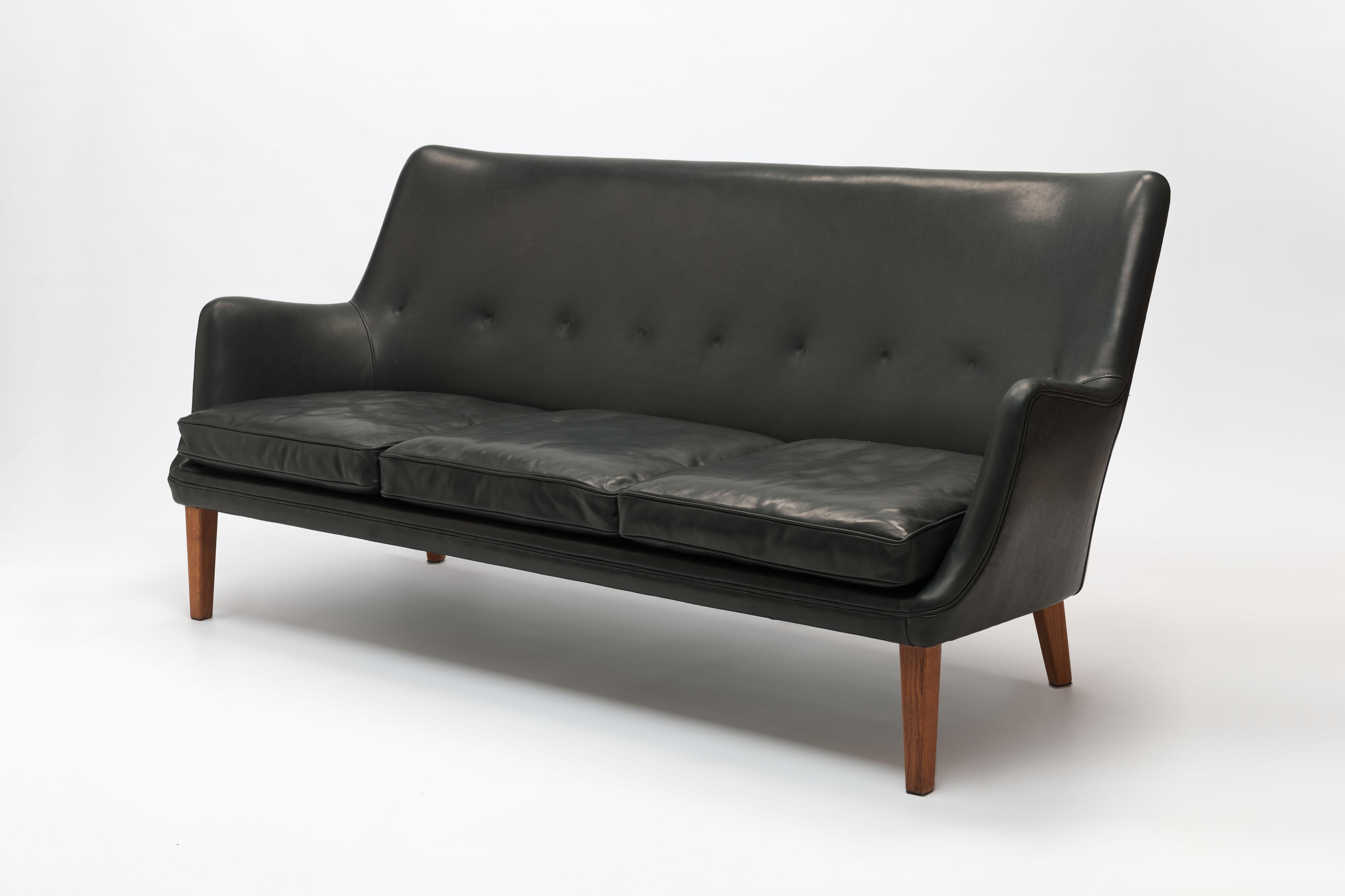 Refined black leather 3-seat sofa model AV53 / 3 by Danish designer Arne Vodder, designed in 1953 for Ivan Schlechter, Denmark. This beautiful organic design is characterized by the special way in which the back is 'tufted', not with buttons from