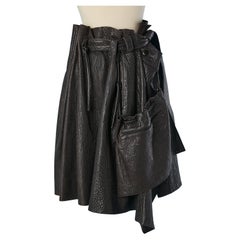 Jupe portefeuille asymétrique en cuir noir avec sac en cuir sur le devant Issey Miyake