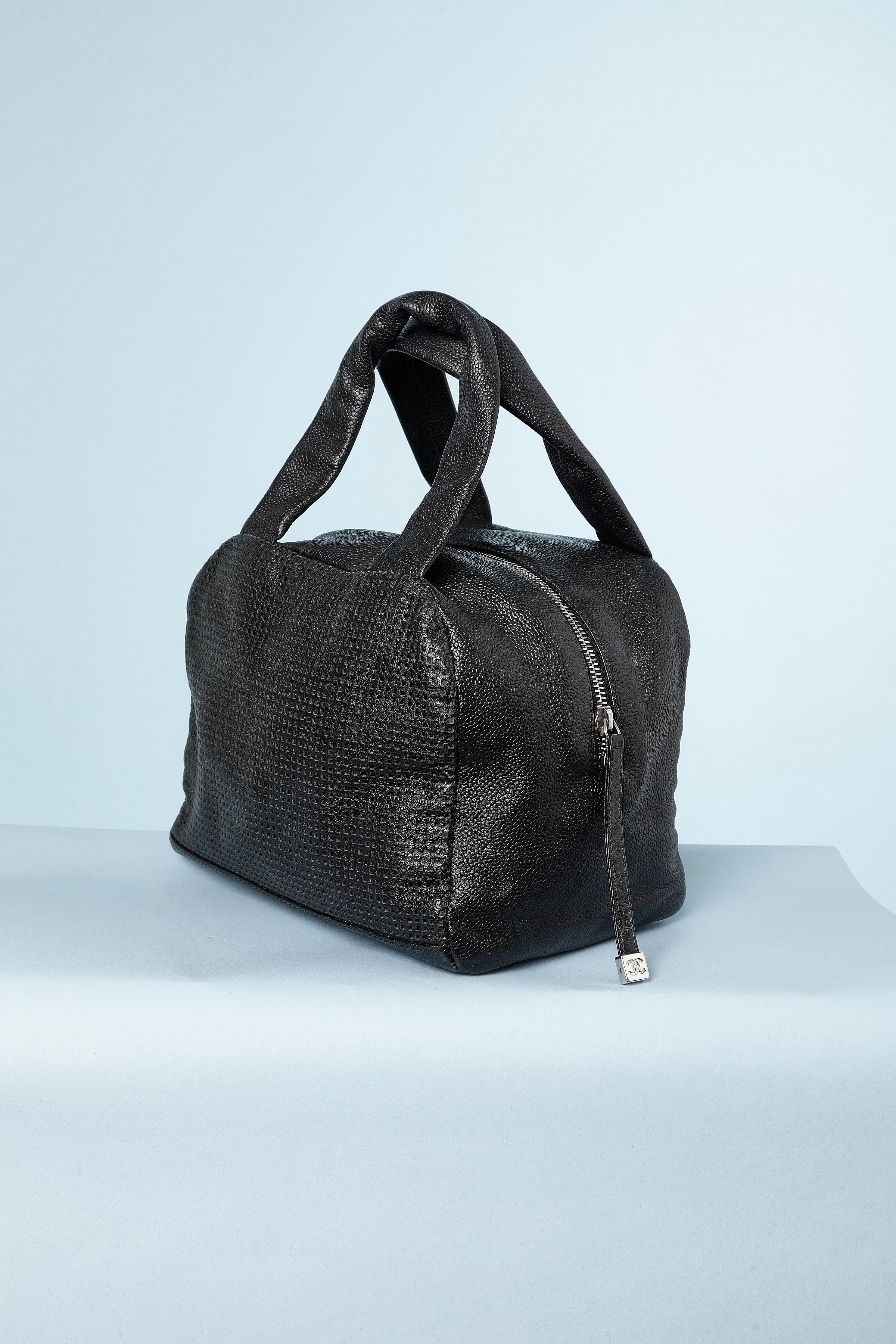 Black leather bag perforated with double C and zip . Numbered: 9579105
Branded fabric lining. 
Size: 
- Height= 17 cm
- Width= 21 cm
- Depth = 16 cm
Protection studs under the bag.