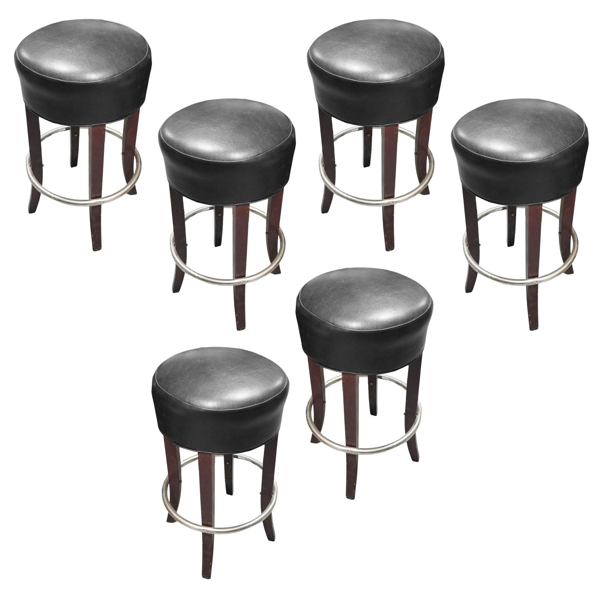 Set of 17 black backless round upholstered bar stools with an upholstered padded box seat and silver round footrest.

A sleek set of 17 black leather bar stools, the epitome of modern elegance. With a minimalist design, these stools offer both