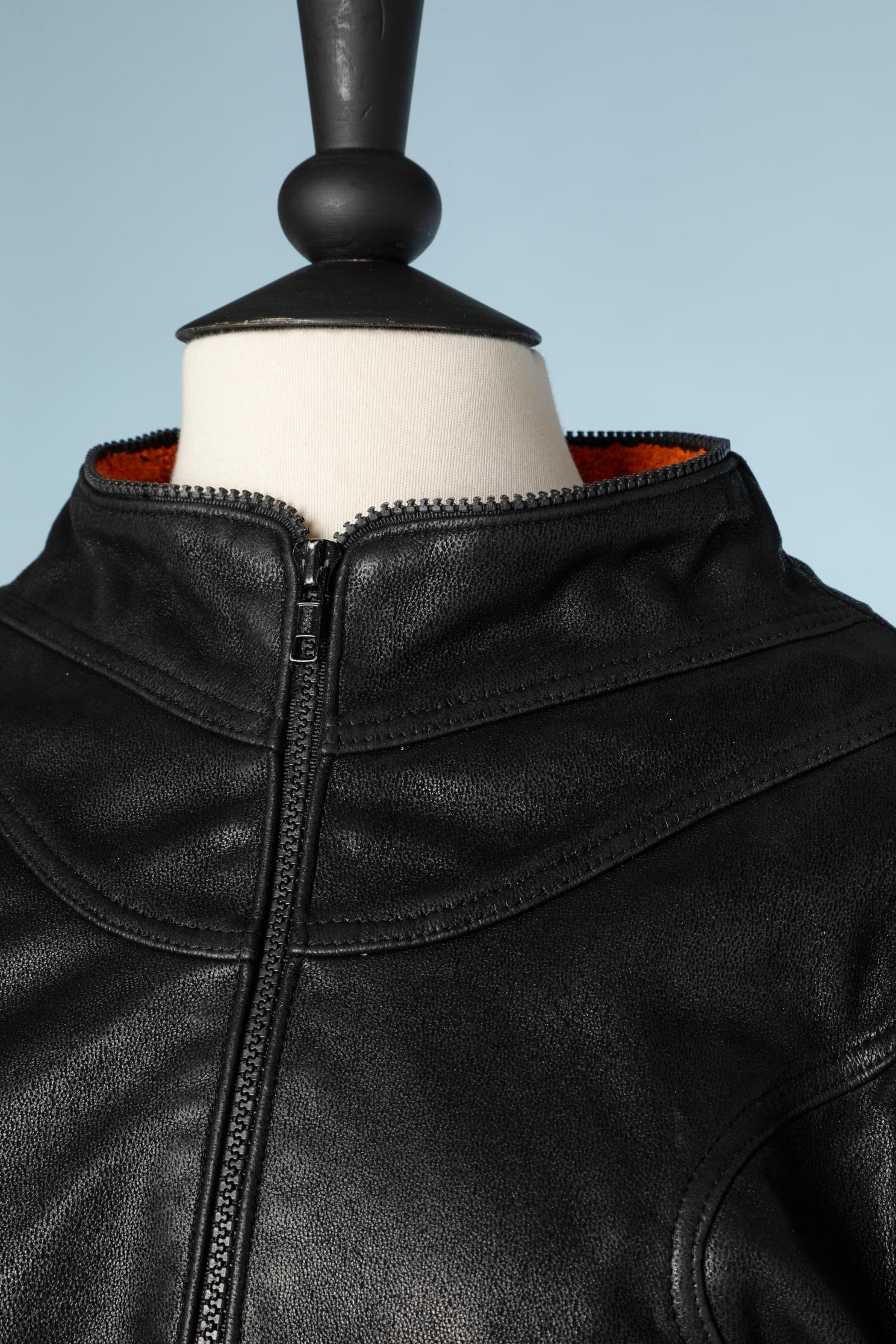 Black leather biker jacket with orange and blue terry towelling lining. (Orange inside the body and blue inside the sleeves.)
SIZE: 38 ( small) 
Half zip embellishment all along the edge of the jacket ( neck-line, bottom edge and cuffs)