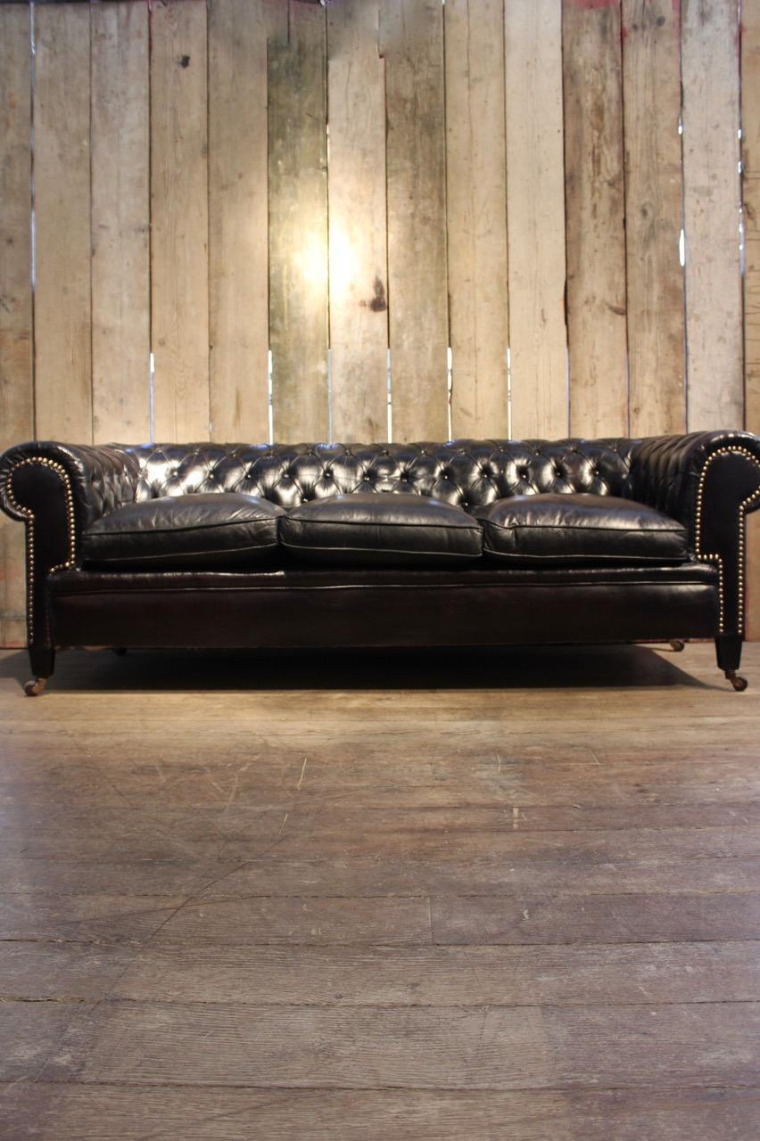 An impressive buttoned black leather chesterfield sofa, French, mid-20th century 

Seat height 55 cm.