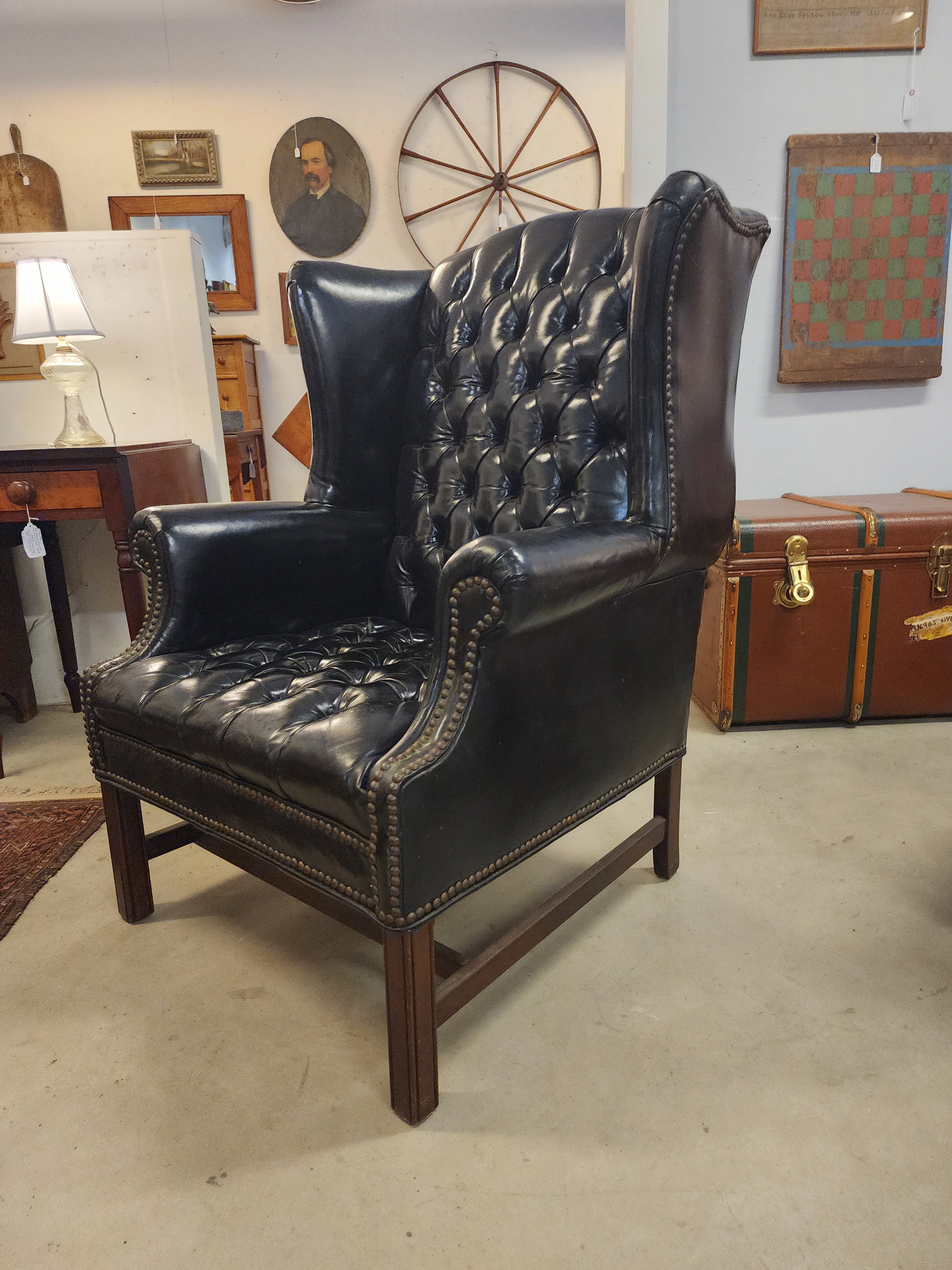 Great black leather wing back chair with lots of personality. Tufted and buttoned with beautiful nail head work. Comfortable strong and an excellent vintage condition. Would add sculptural presents to any room in your home.