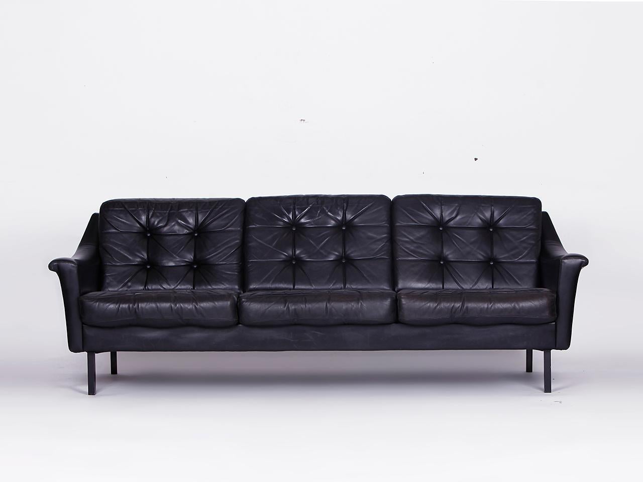 Black leather couch and 2 armchairs, Germany 1960s. 
This set of seats made of genuine leather is in a good condition with traces of use according to its age. 
Dimensions:
Armchair - H 71, W 85, D 83cm. 
Couch - H 71, W 200, D 83cm.