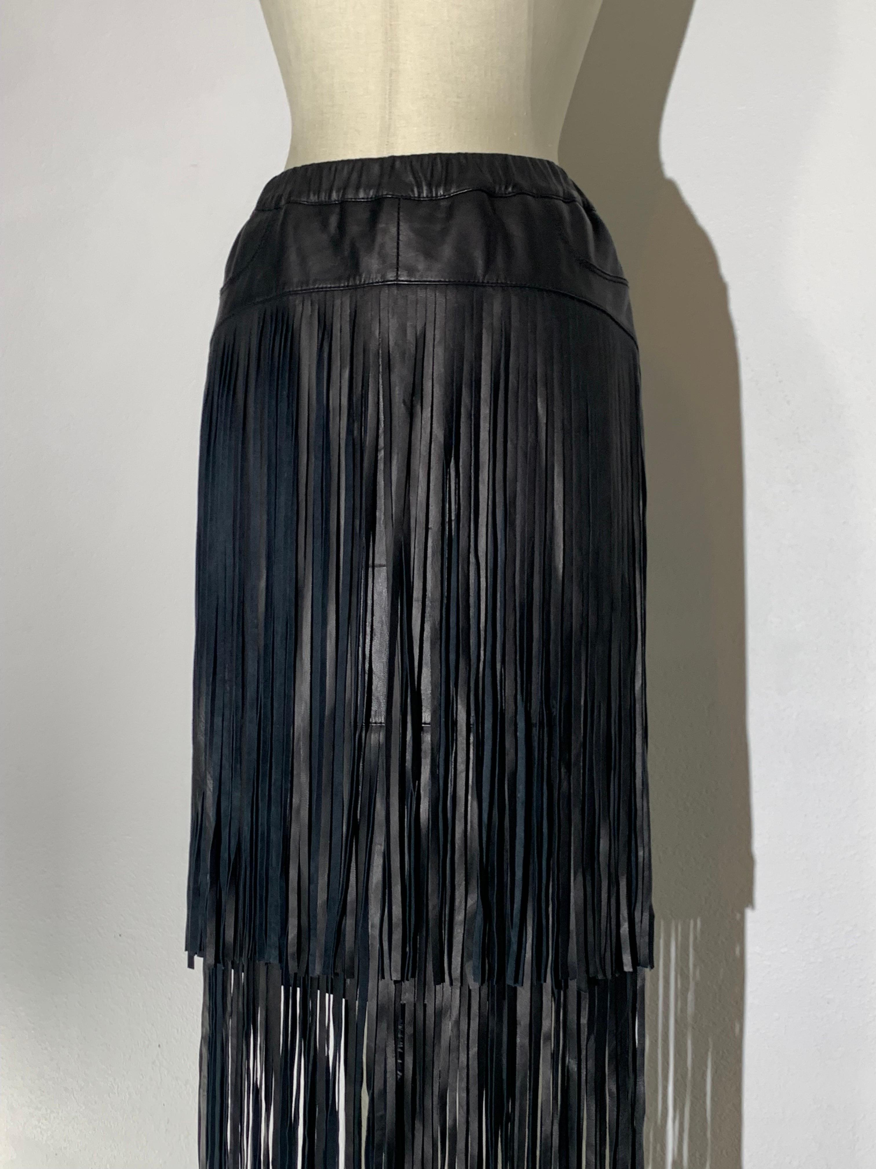 Black Leather Mini Skirt w/ Double Tiered Longer Leather Peek-A-Boo Fringe:  Made by Philanthropy. Glossy fine lambskin leather lined in satin. Elasticized waistband. Fitted hip panel with fringe cascading from it in double tiers. US size Small.