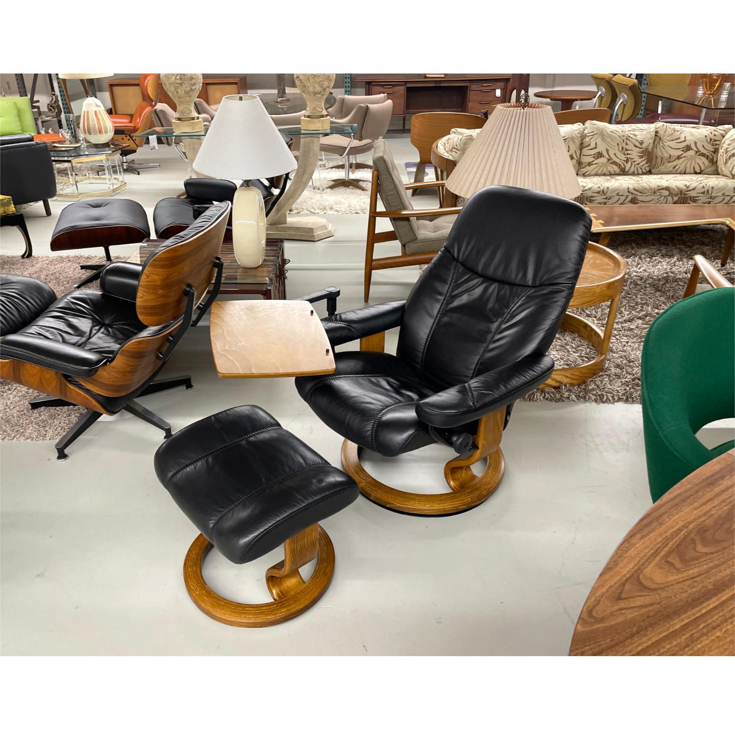 Black leather Ekornes Stressless chair complete with ottoman and removable computer table. This pre-owned Ekornes Stressless chair is in great condition. The same can be said for the ottoman and the personal table. Ekornes Stressless has become