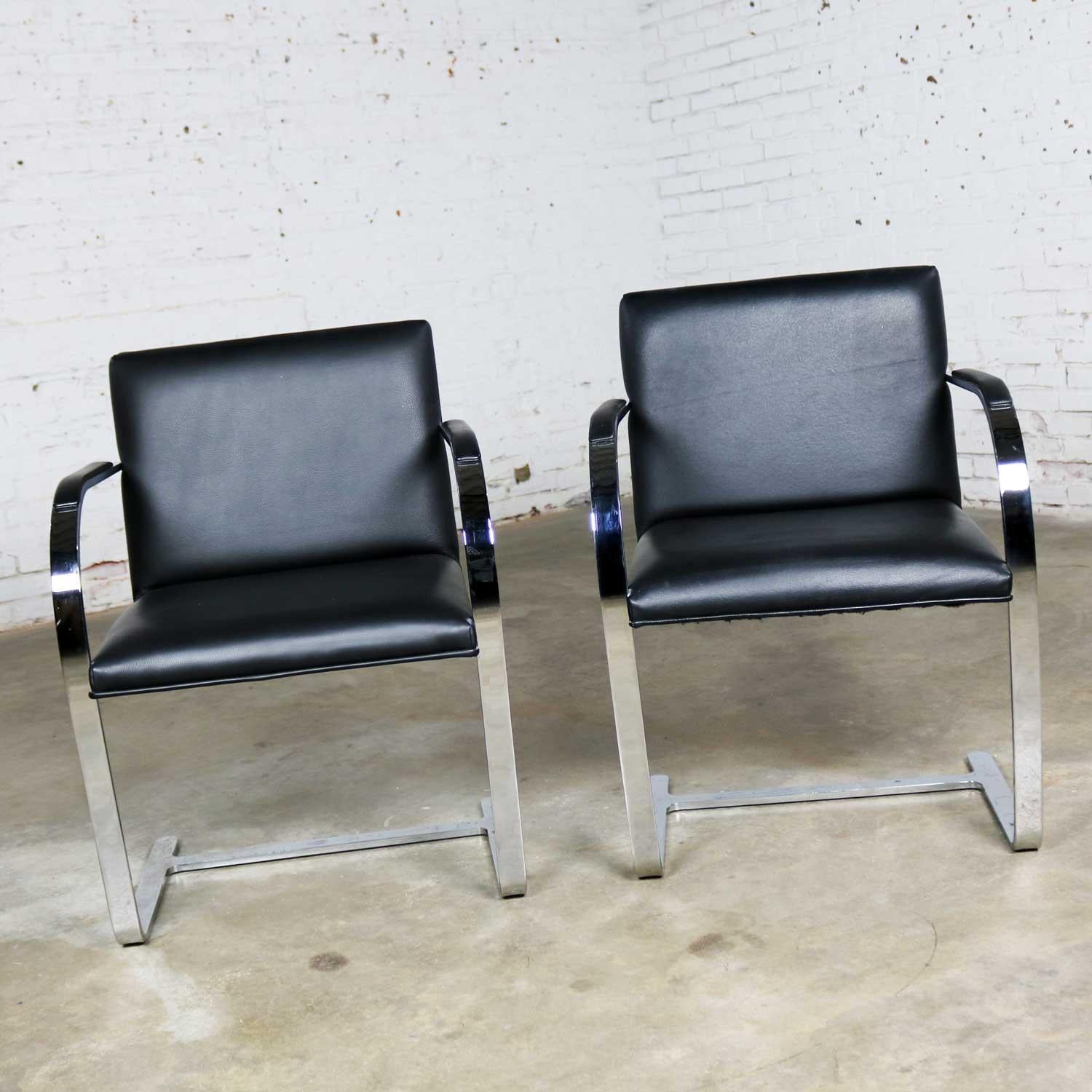 Handsome pair of black leather and chrome flat bar Brno chairs designed by Mies Van Der Rohe and Lilly Reich produced by Gordon International. One is in wonderful vintage condition. The other is in almost wonderful condition. The leather on both is