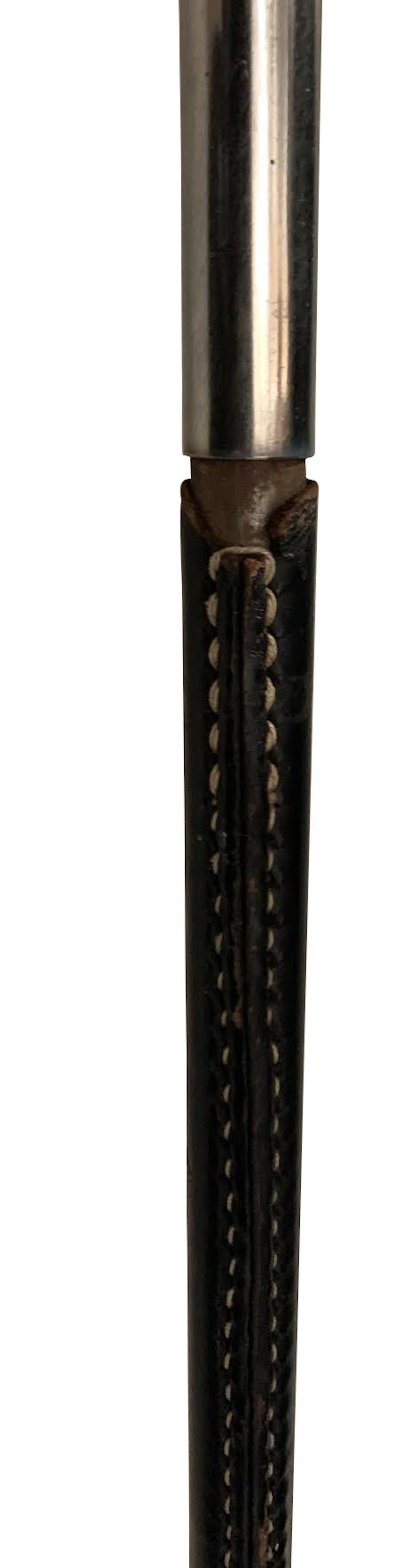 Spanische Stehlampe aus schwarzem Leder aus den 1960er Jahren.
Weiße Kontrastnähte.
Silberner Dreibein-Sockel.
Höhe der Leuchte 49