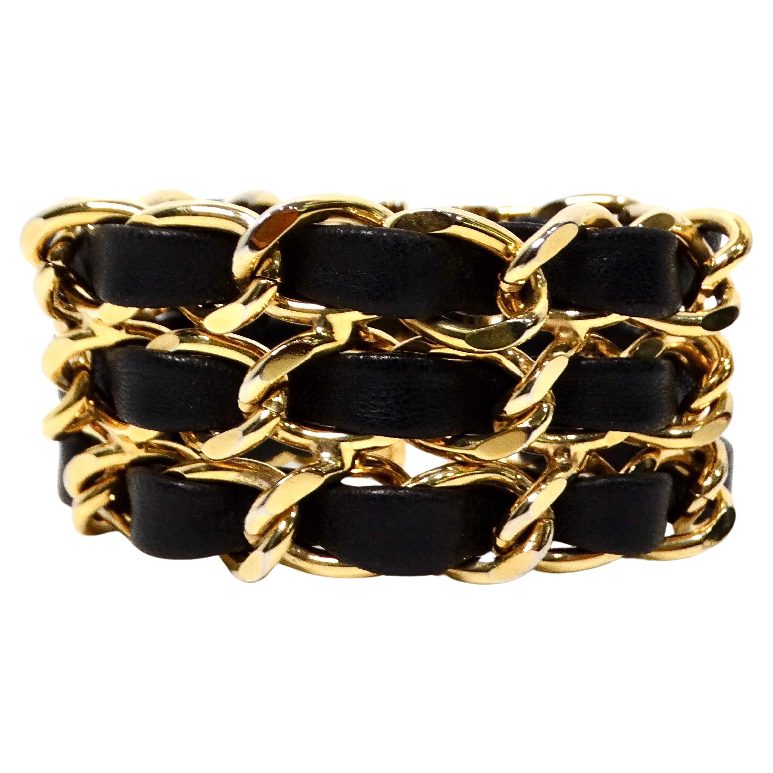 This striking Black Leather & Gold-Tone Chain Link Cuff Bracelet from the circa 1990s exemplifies the bold, edgy aesthetic that defined the era’s jewelry fashion. The combination of rich black leather with the shimmering gold-tone chain links