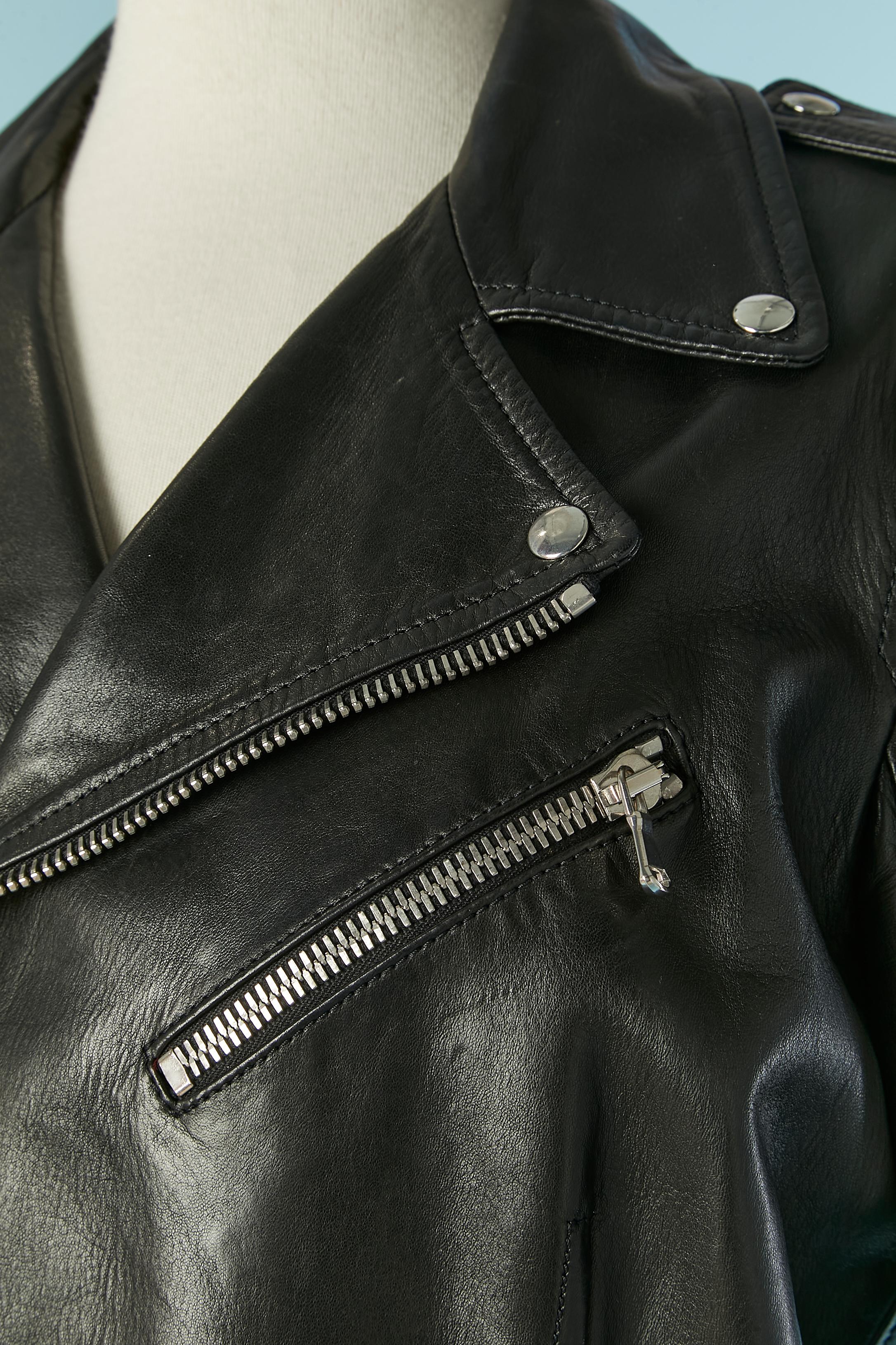 Black leather jacket with zip closure on the front and on the pockets. Red silk lining. Zip closure on the bottom edge of the sleeve as well. Cut-work. Belt with buckle closure and Half-belt on the back with buckle closure. 
SIZE 44 (It) 40 (Fr) M 