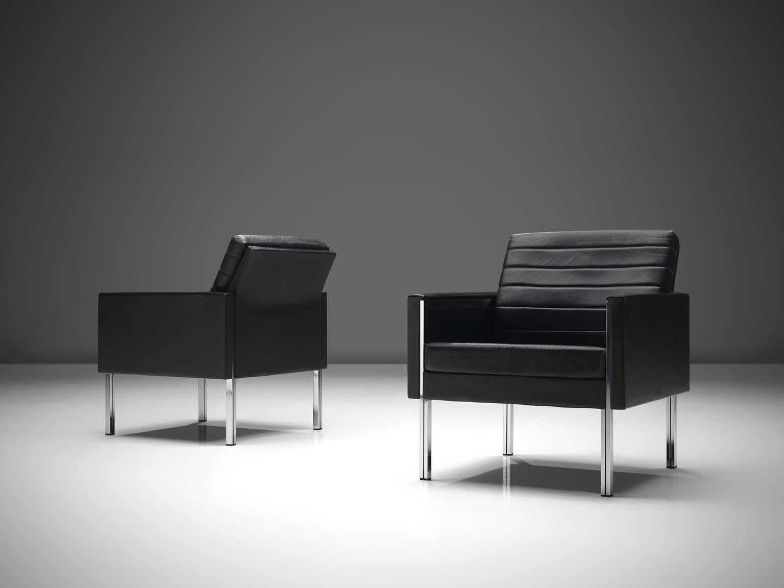Black leather and steel, Europe, 1960s. 

These comfortable chairs shows elegant steel details that run all the way to the top of the armrests. The combination of steel and the black leather upholstery give these chairs their modern and