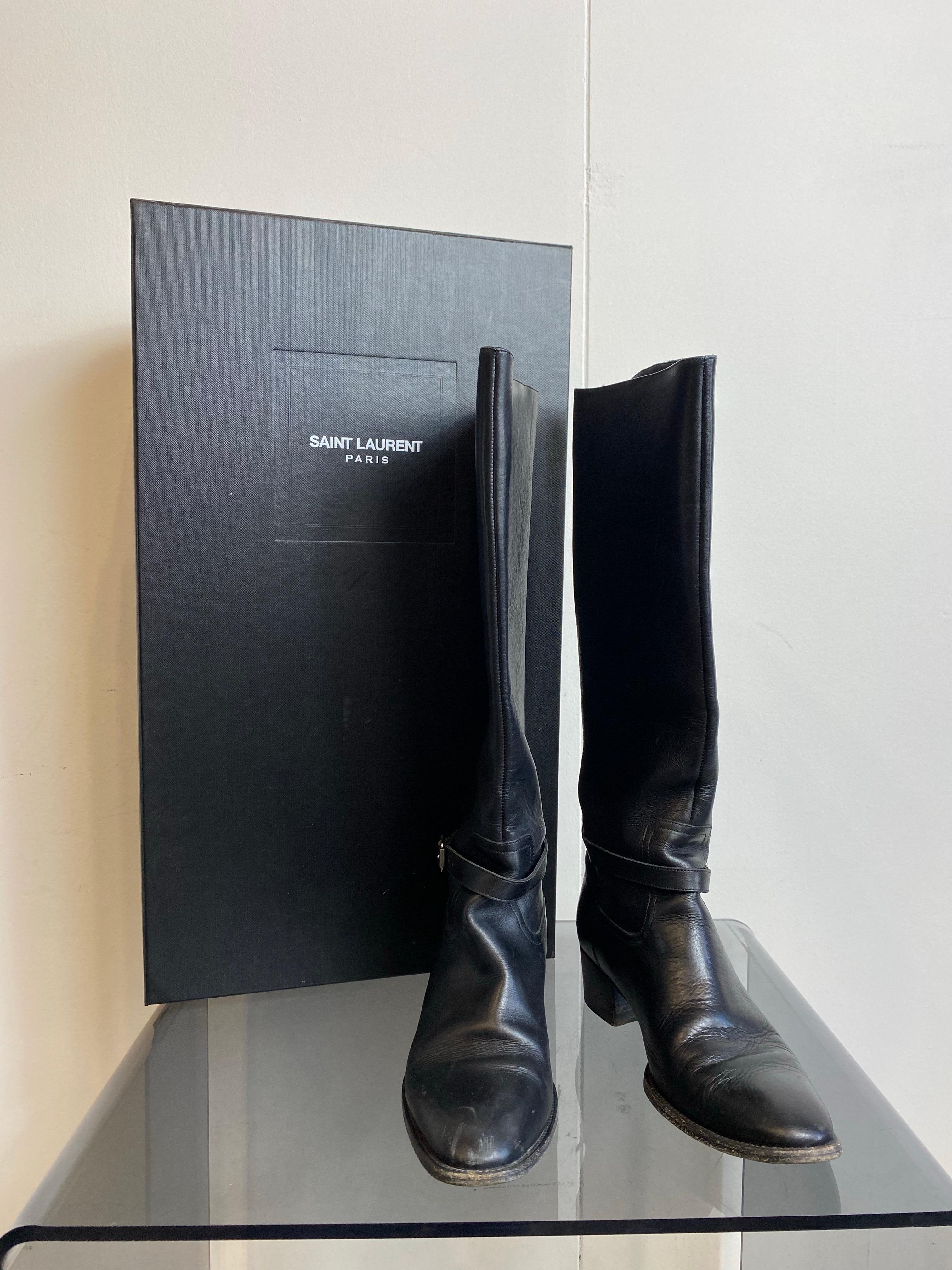 Schwarze Saint Laurent Stiefel aus Leder mit silbernen Metalldetails. Sie weisen einige Gebrauchsspuren auf, wie auf den Fotos zu sehen ist. 
Größe 38 
Höhe 40 cm 
Absatz 4 cm 
Mit Originalverpackung.