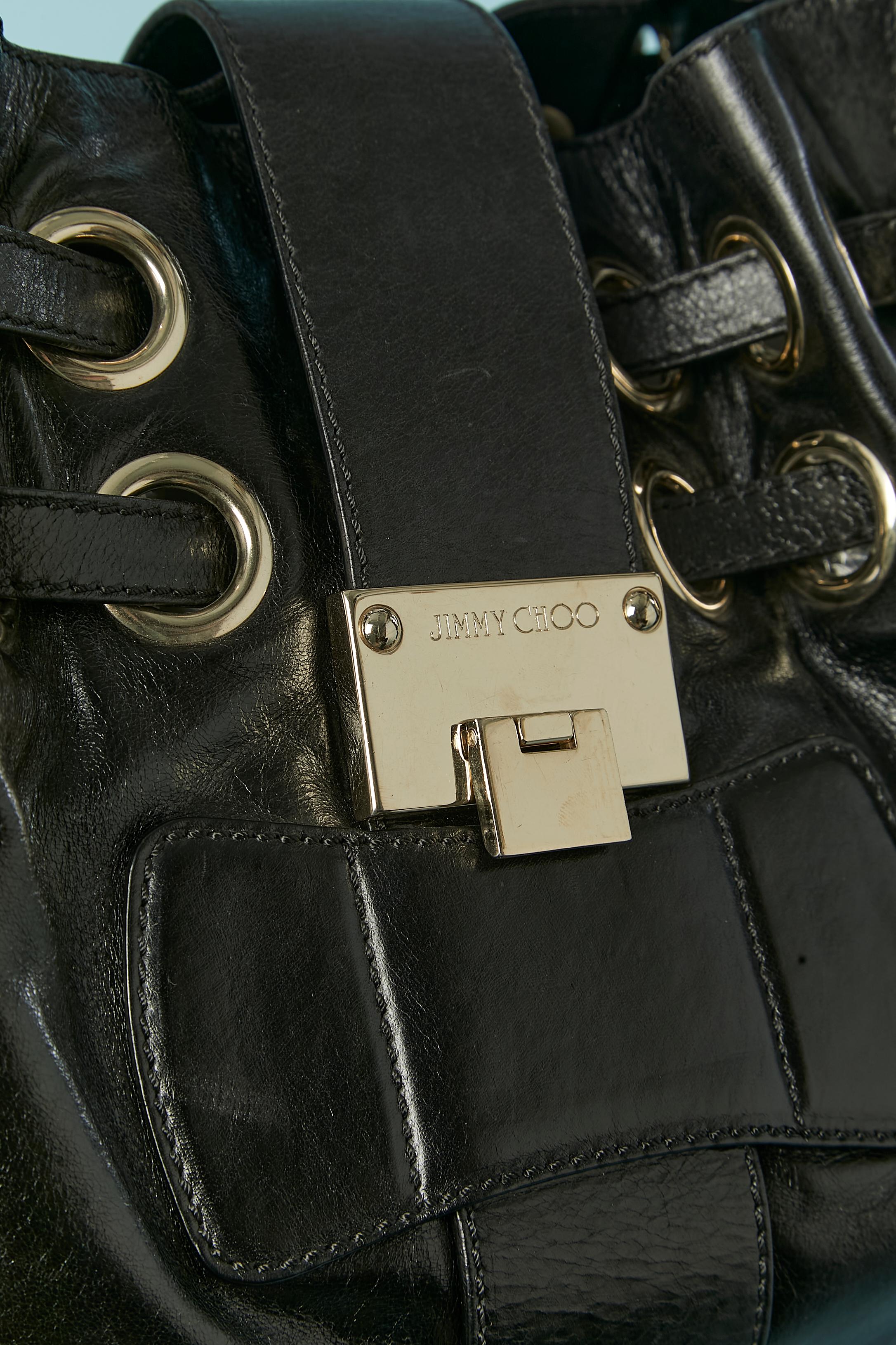 Black leather shoulder bag. Gold metal hardware clasp on the front. 4 pockets inside: one flat with zip, one flat without zip and 2 on both side with branded snap closure. Beige suede lining and lilac gros-grain piping. 
SIZE : 40cm X 28cm X 14 cm