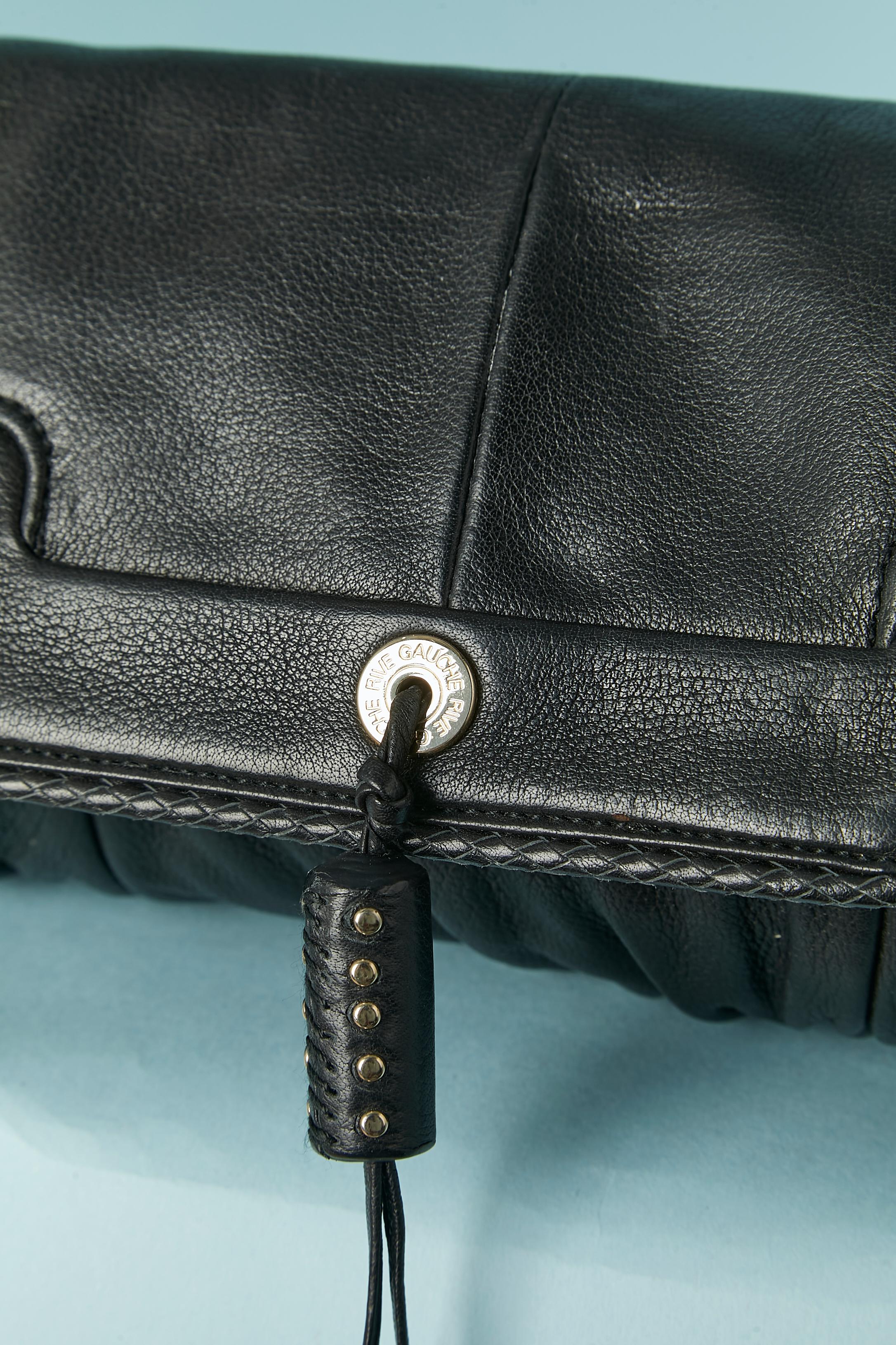 Black leather shoulder small bag ( or clutch) . Black satin lining. Adjustable and removable shoulder-strap. Flat pocket inside. Snap closure middle front with leather tassel with gold metal studs embellishment.
SIZE : 25cm X 12cm X 6cm
Shoulder's