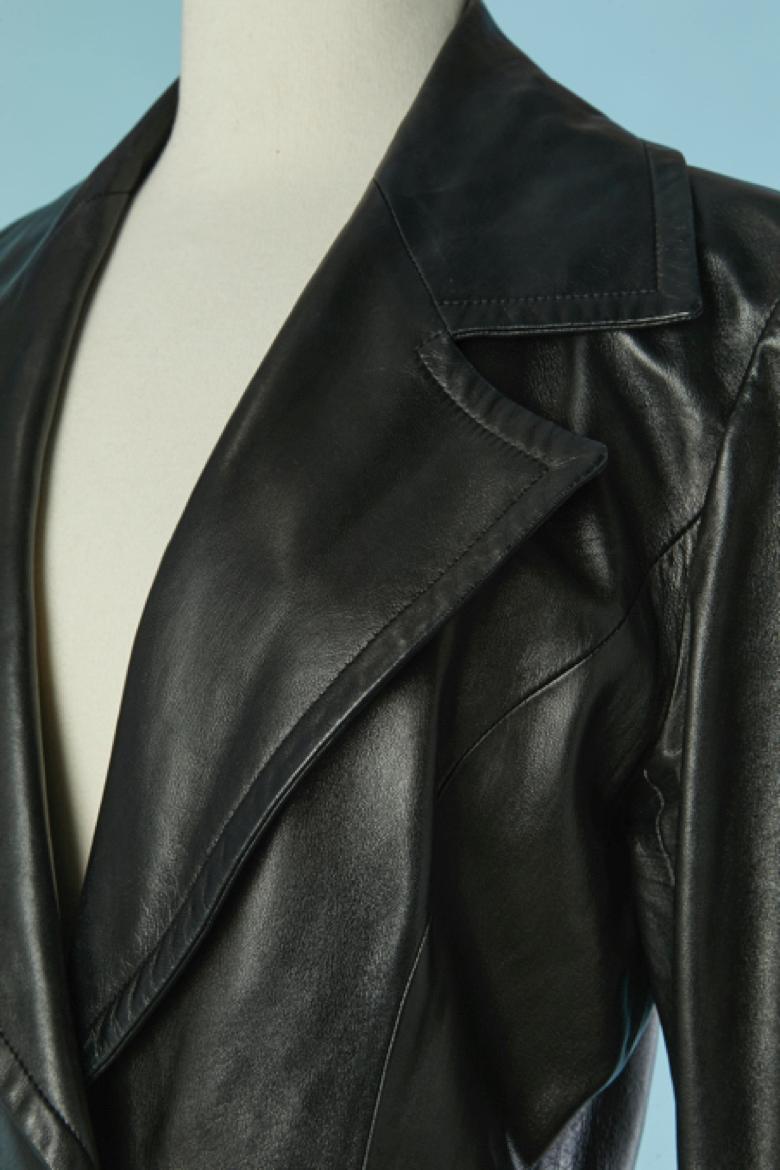 Cappotto monopetto in pelle nera. Fodera in acetato. Chiusura con un bottone e un'asola al centro della fronte. Tasca su entrambi i lati. 
TAGLIA 38 (Fr) M 