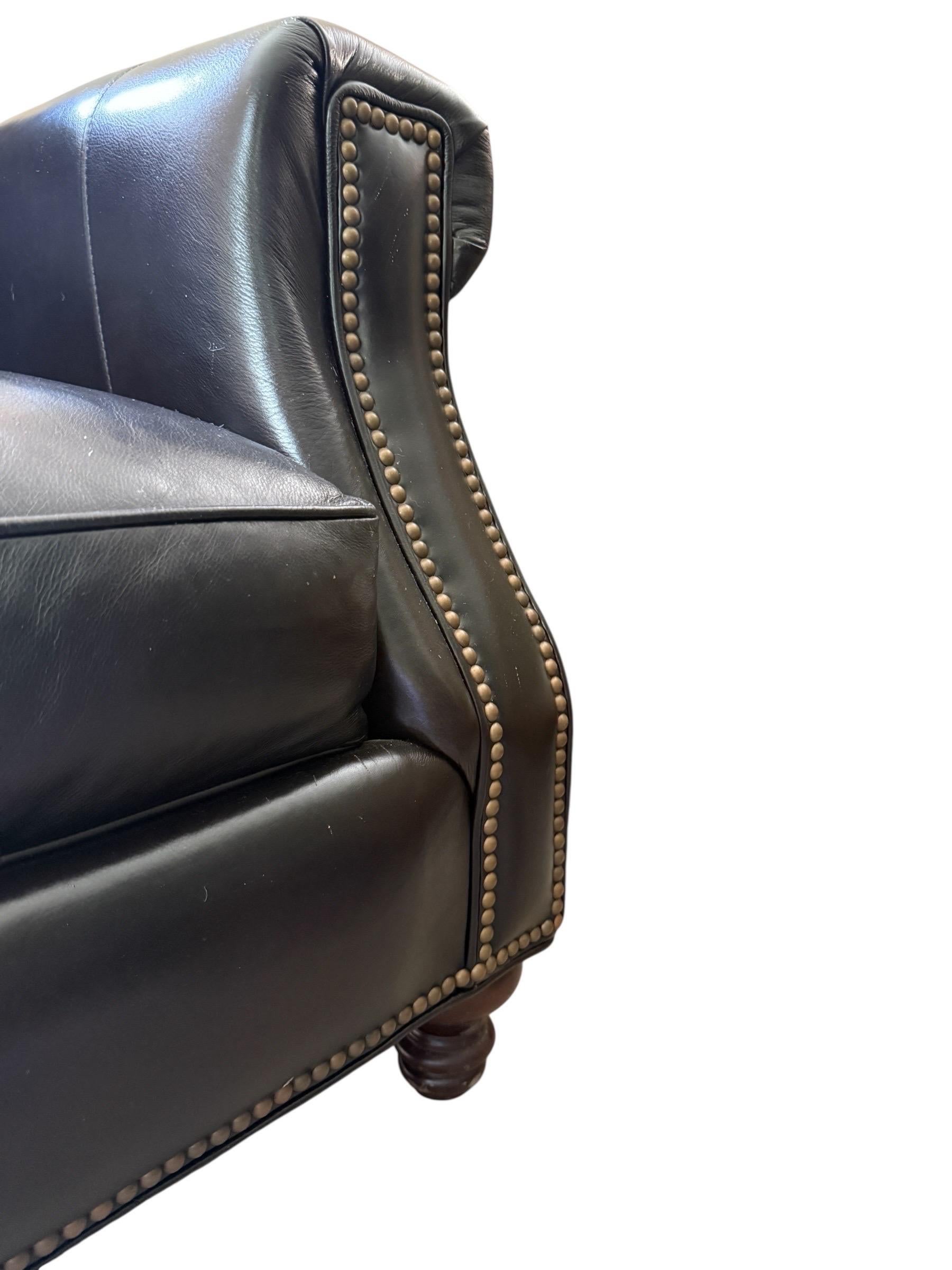 Glamorous lush and grand! This vintage black leather sofa is a powerhouse piece. With brass tack detailing and shiney black leather with a brown hint, this is a “sink into me” kind of sofa. This large spacious couch was barely in use if