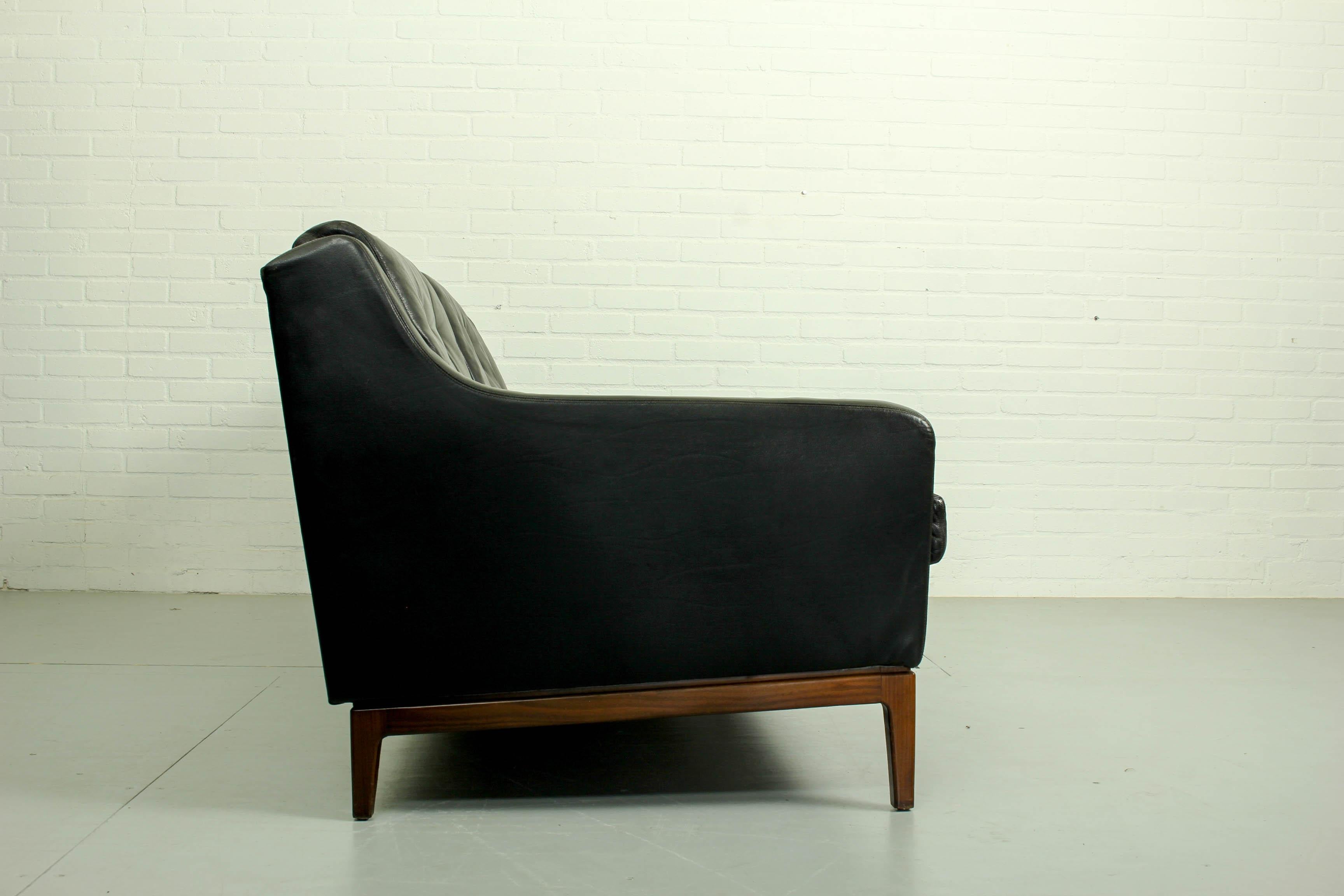 A 1960's black leather three seater sofa and matching lounge chair by unknown designer. With beautiful teak frame and original leather. Overall the leather upholstery is in very good condition, on one side of the chair there is a scratch (only