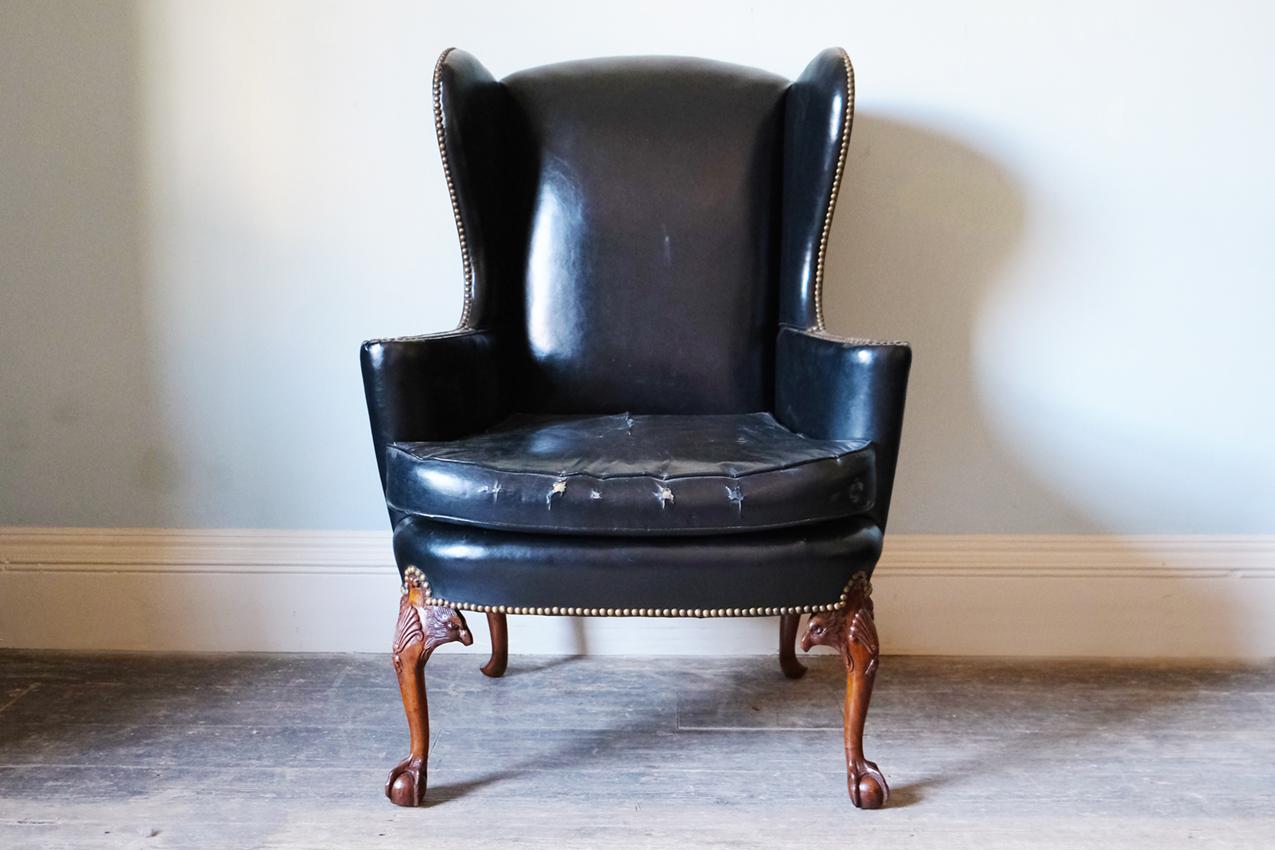A restored black leather-upholstered wingback armchair, outlined with a close nail trim and raised on ball and claw feet (design of eagles claw). 


English, c.1890. Leather, metal & solid wood. 

Dimensions: H115.5 x W83.5 x D75 cm.