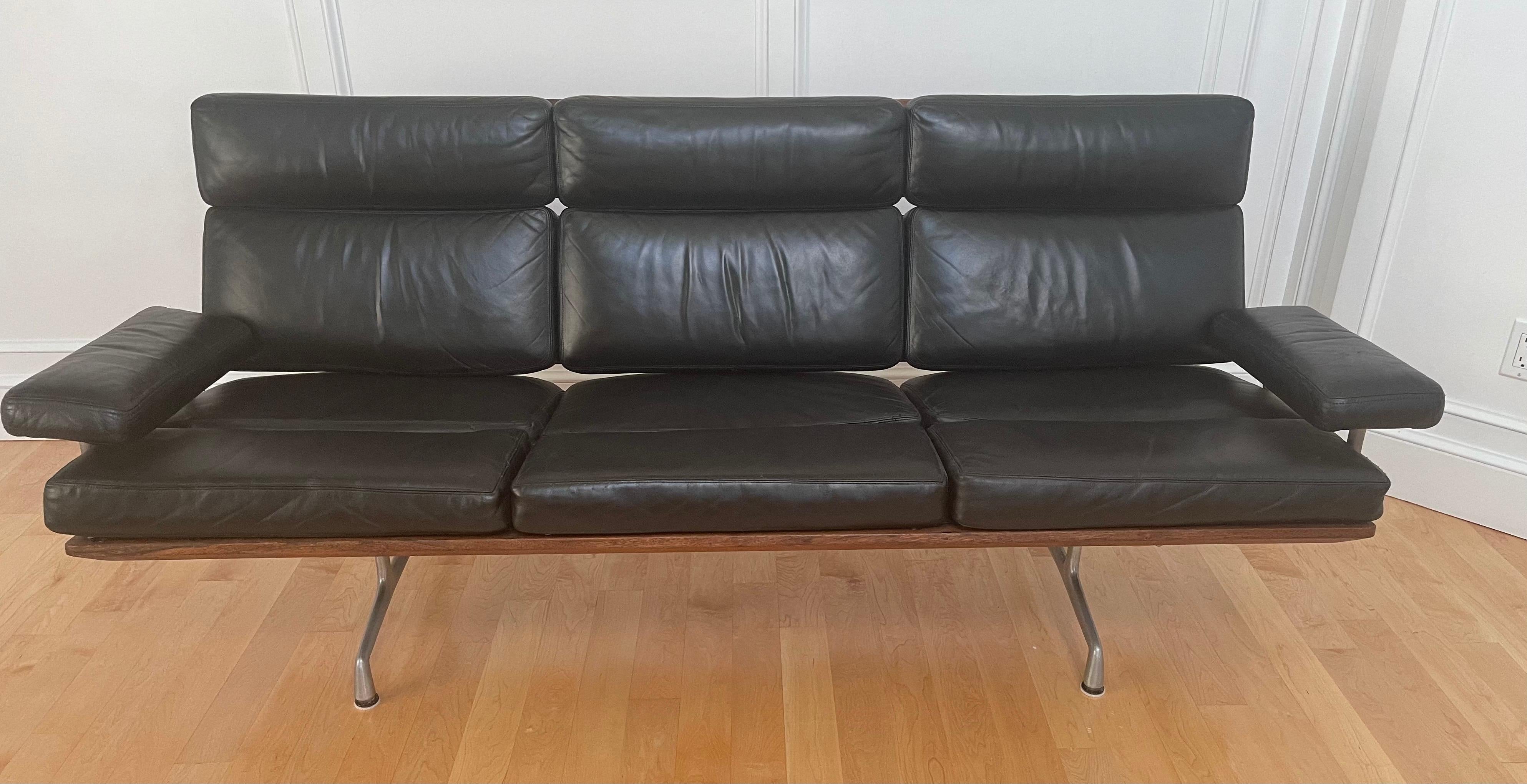 Authentic black leather and walnut three seat sofa by Charles & Ray Eames for Herman Miller, circa mid 1980s (very early production piece). The sofa is in excellent vintage condition and features solid wood back and frame panels finished with