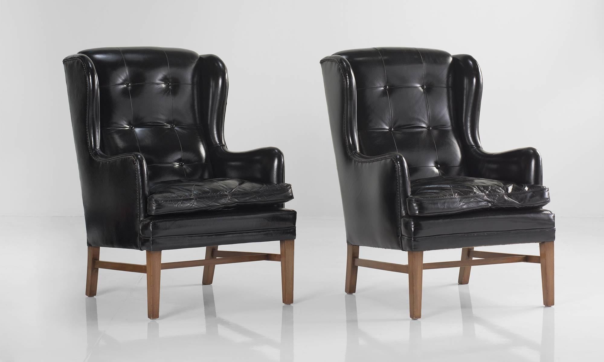 Black leather wing armchairs, Sweden, circa 1950.

Original leather, button back upholstery on walnut color birch frame.