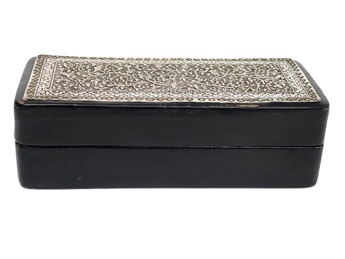 Cuero negro con caja de plata indonesia de los años 20

Una caja rectangular de cuero negro con plata de Indonesia en la parte superior de la tapa 
El interior es de madera
La placa fina de plata hecha a mano tiene un rico motivo floral y de