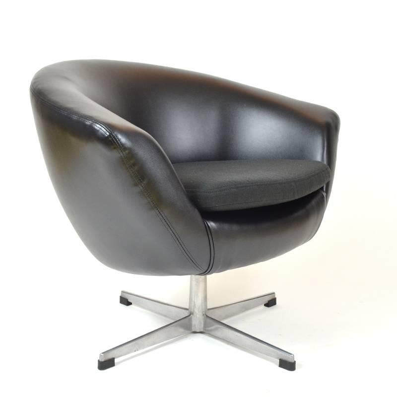 Timeless swivel chair made by UP Zavody Rousinov in former Czechoslovakia. It features new upholstery in artificial leather with a cushion in black furniture fabric. 1970s design period.
