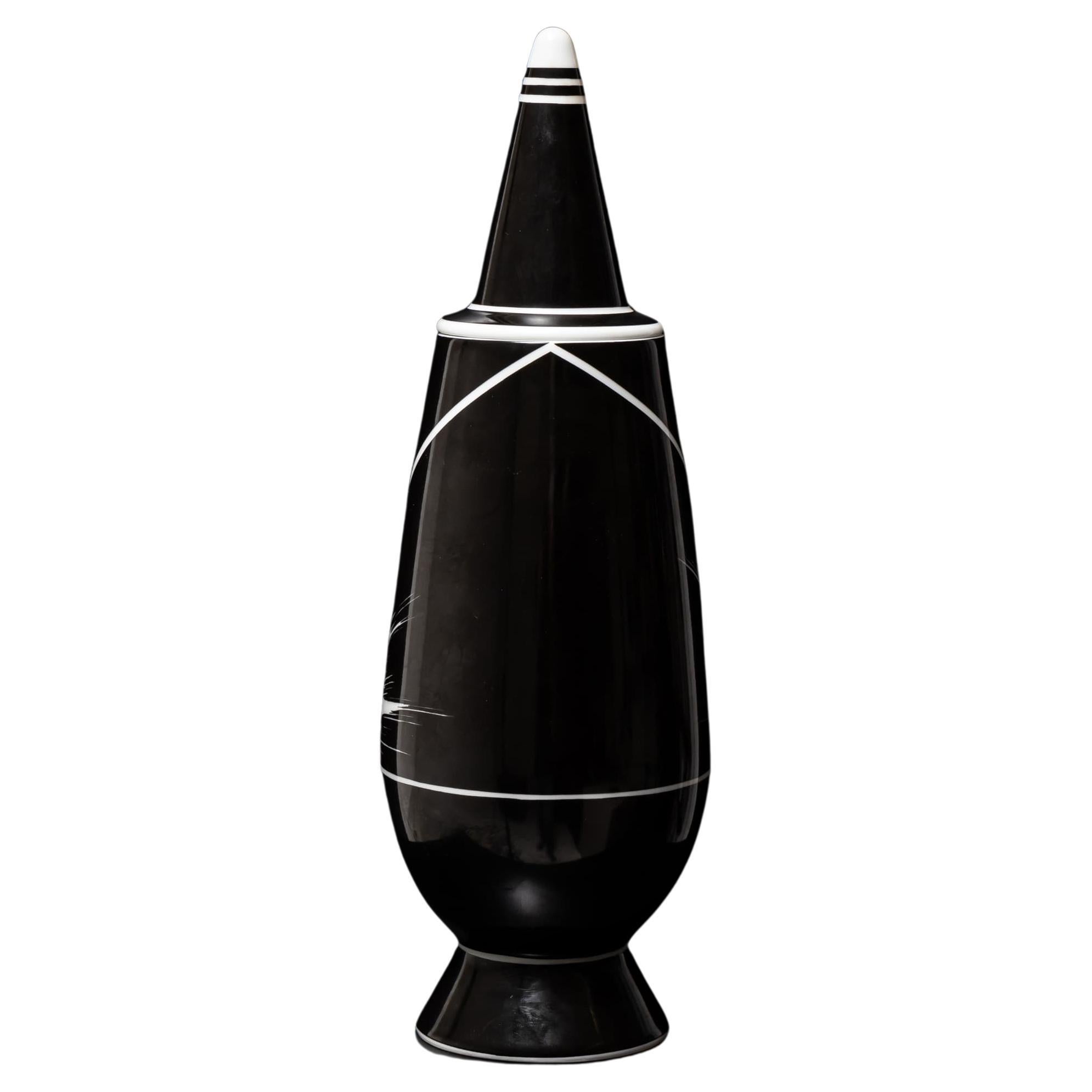 Porzellanvase in limitierter Auflage aus der ikonischen Serie von Alessandro Mendini für Alessi. Die kugelförmige Form ist einfach und doch kraftvoll und dient als Leinwand für ein kollektives künstlerisches Experiment: 
Diese schwarze Vase ist Teil
