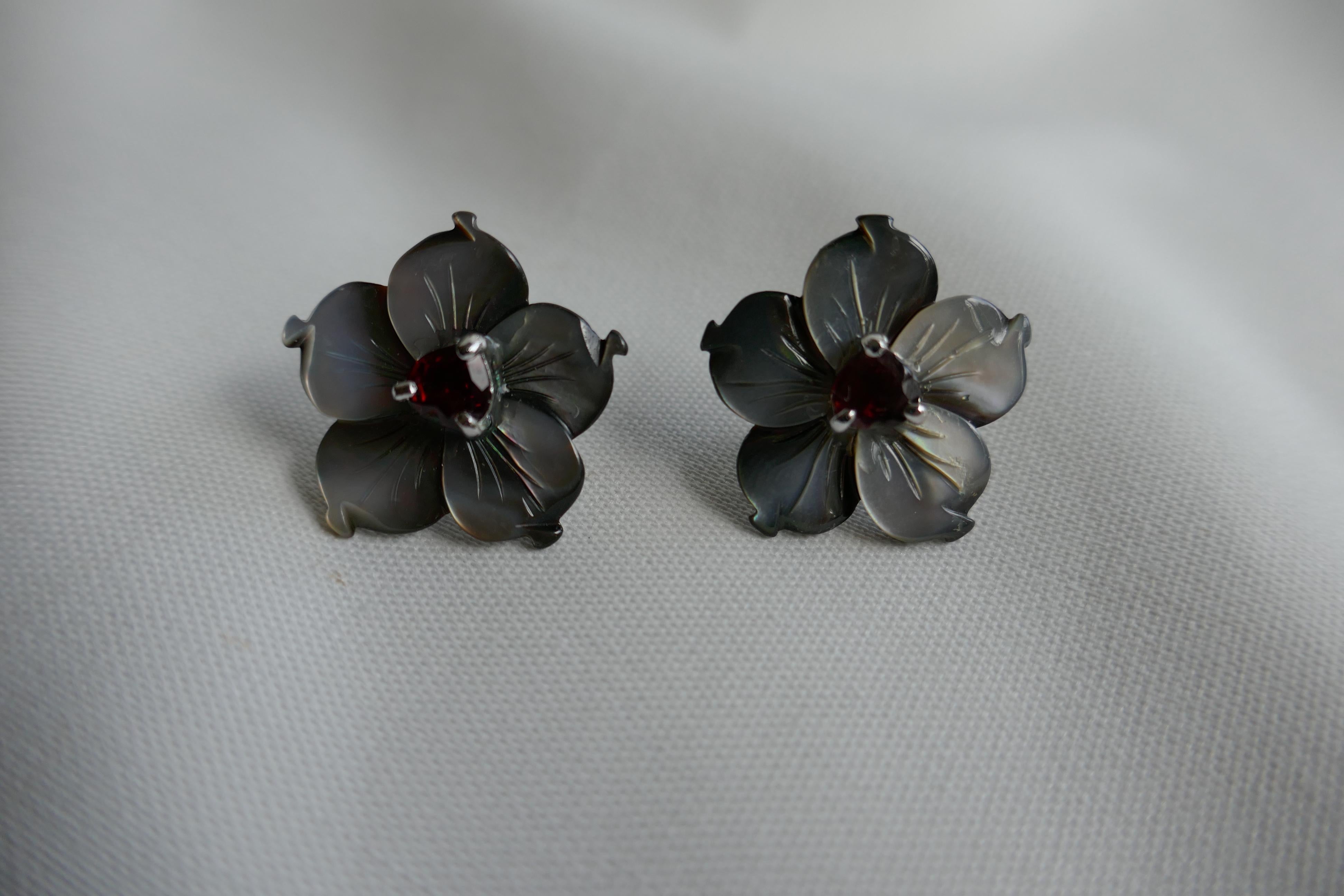 These earrings are easy to wear. The come in various combinations of Black lip Mother of Pearl flowers and center stones or pearls. The Black lip mother-of-pearl in this earring is combined with an amethyst stone center.  The flower is 1 inch in